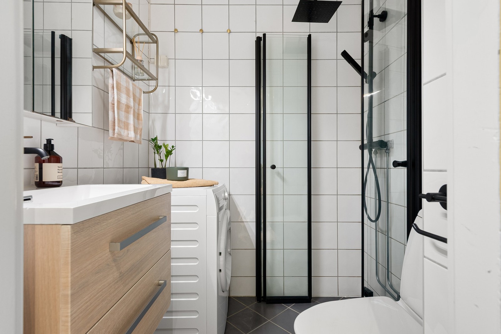 Flislagt bad med praktisk opplegg for vaskemaskin. Galleribilde