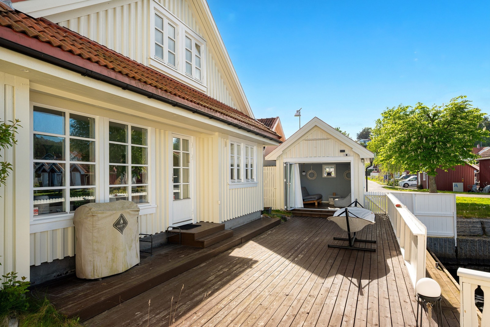 Brygge og terrasse i ett. Sjøboden benyttes også som uteplass sene sommerkvelder og når solen ikke skinner slik som her. Galleribilde