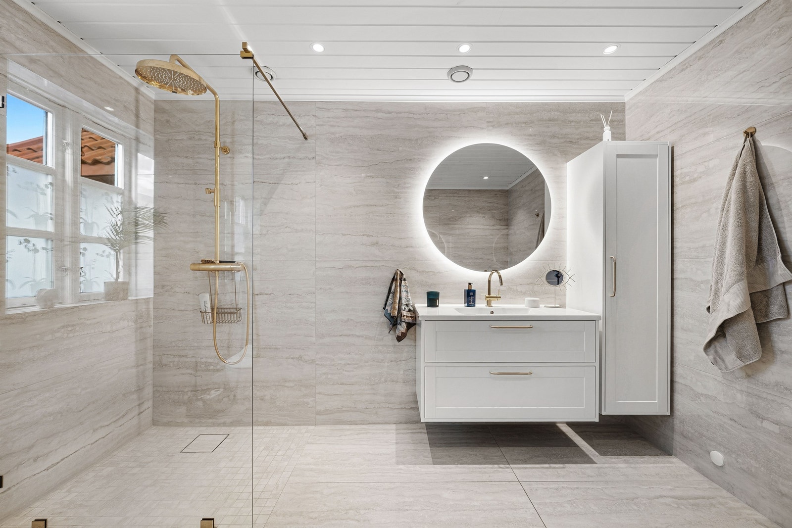 Dette baderommet i hovedetasjen er moderne med store flis, servant , skap, wc, dusjnisje og opplegg til vaskemaskin. Galleribilde