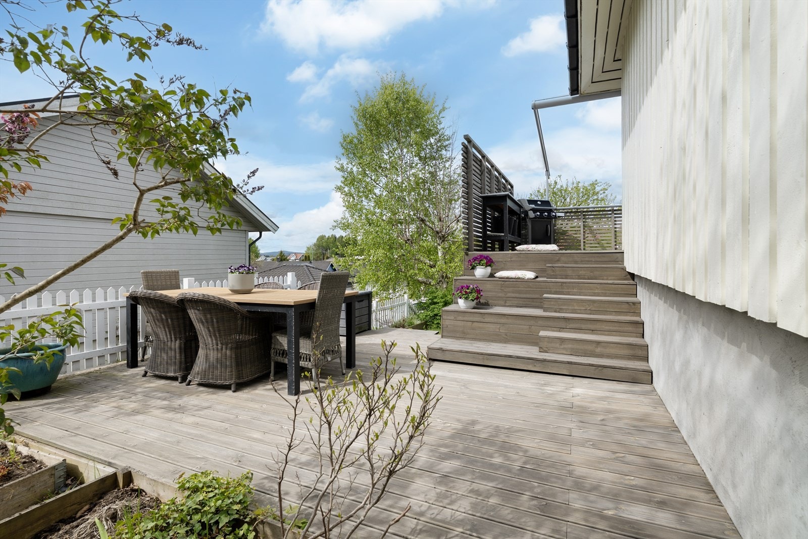 Tomten er opparbeidet med plen, beplantning og flere uteplasser. Galleribilde