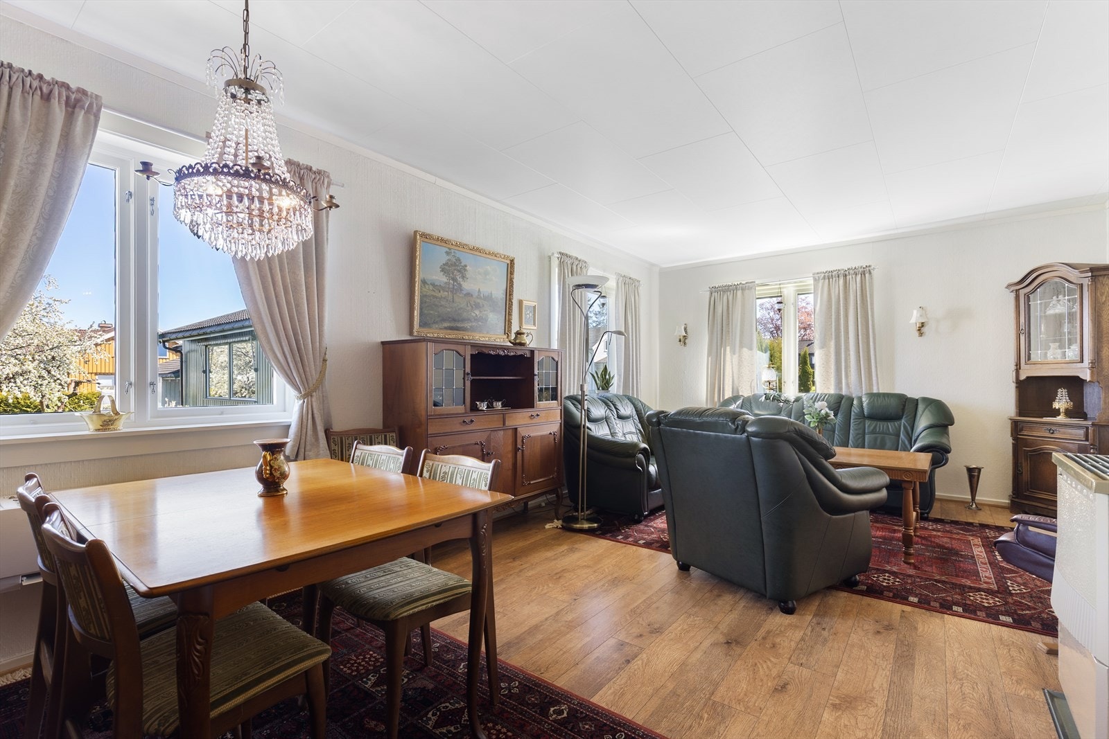 Stuen har plass til både sofagruppe og spisebord, videre er det montert varmepumpe fra 2020. Galleribilde