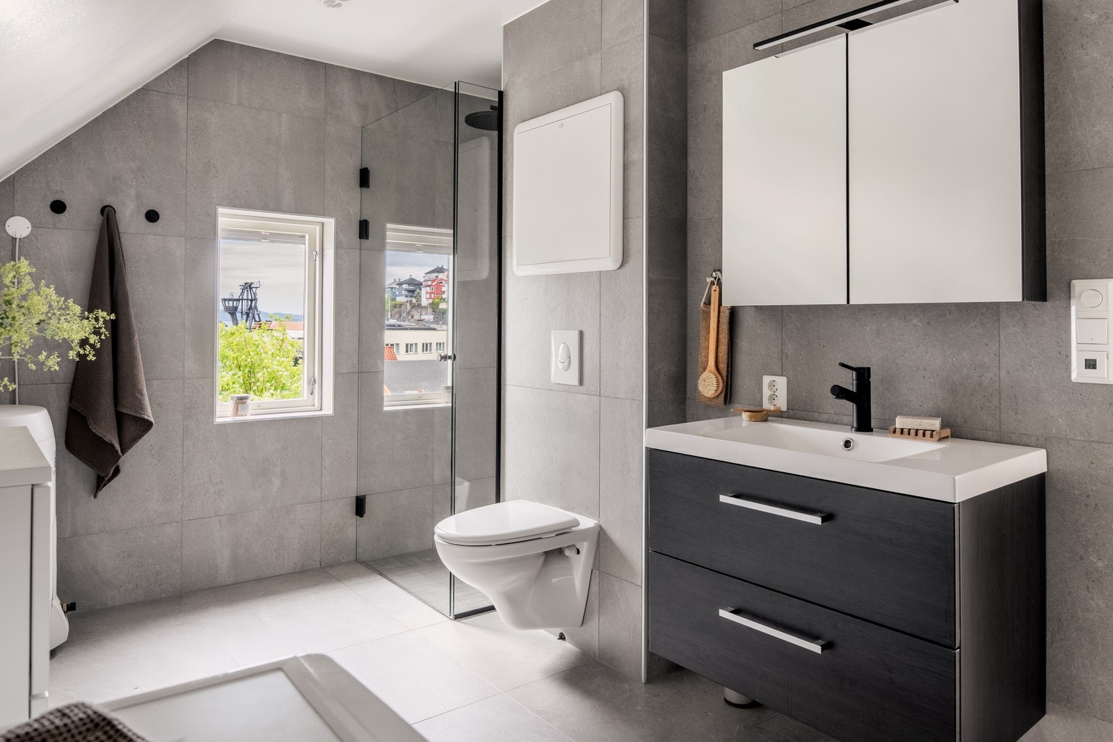 Badet er innredet med vegghengt toalett, dusj og baderomsmøblement med speil og belysning. Galleribilde