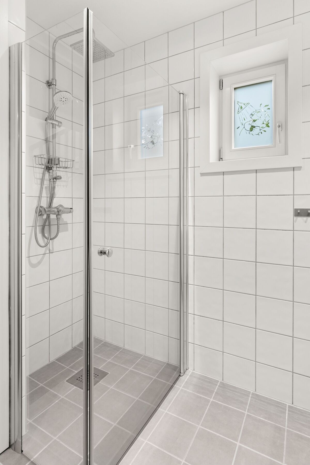 Badet har både oppbevaring og arbeidsflate ved servantmøbelet. Dusjhjørne med glassvegger gir et stilrent uttrykk. Galleribilde
