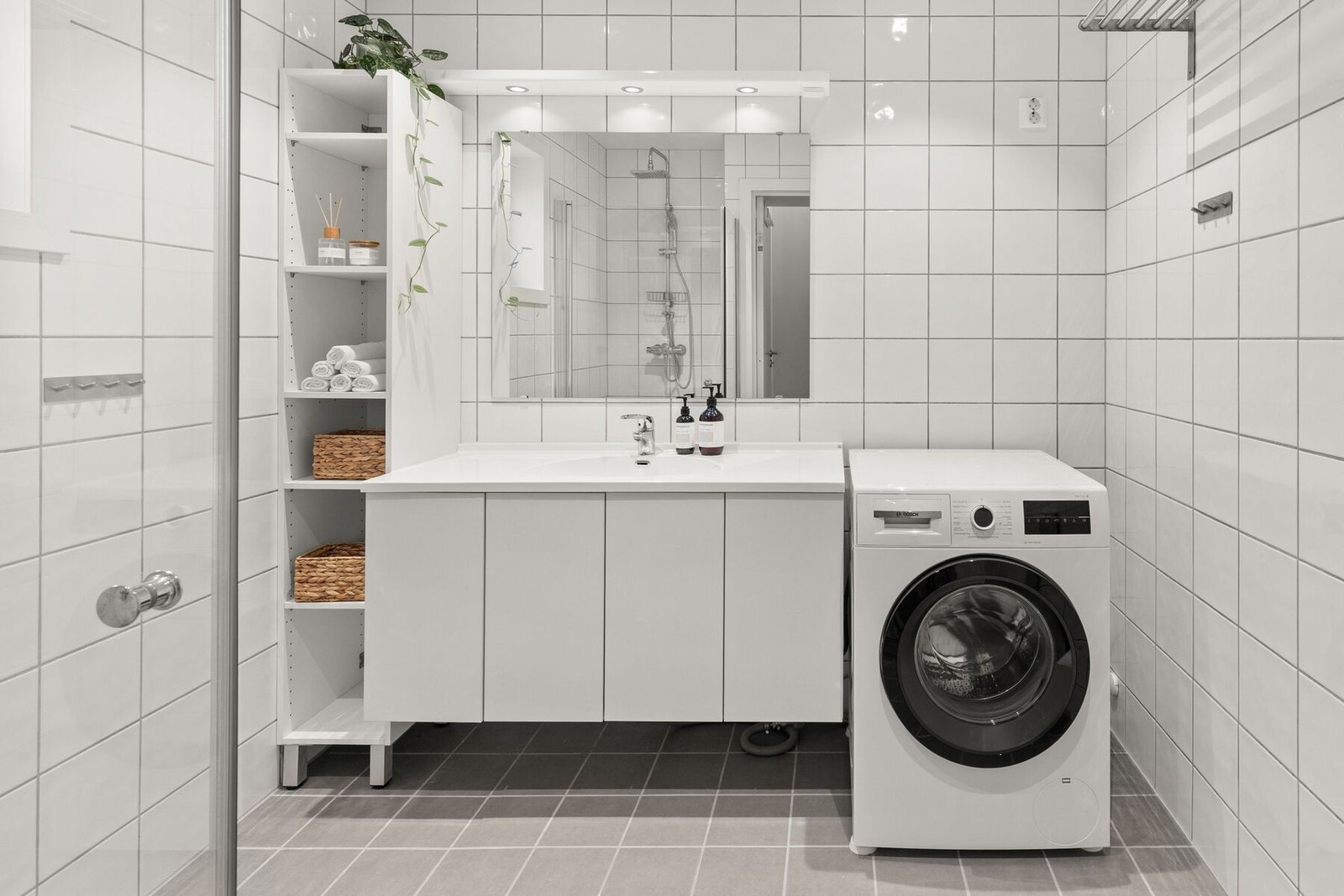 Badet har en praktisk innredning med opplegg for vaskemaskin Galleribilde