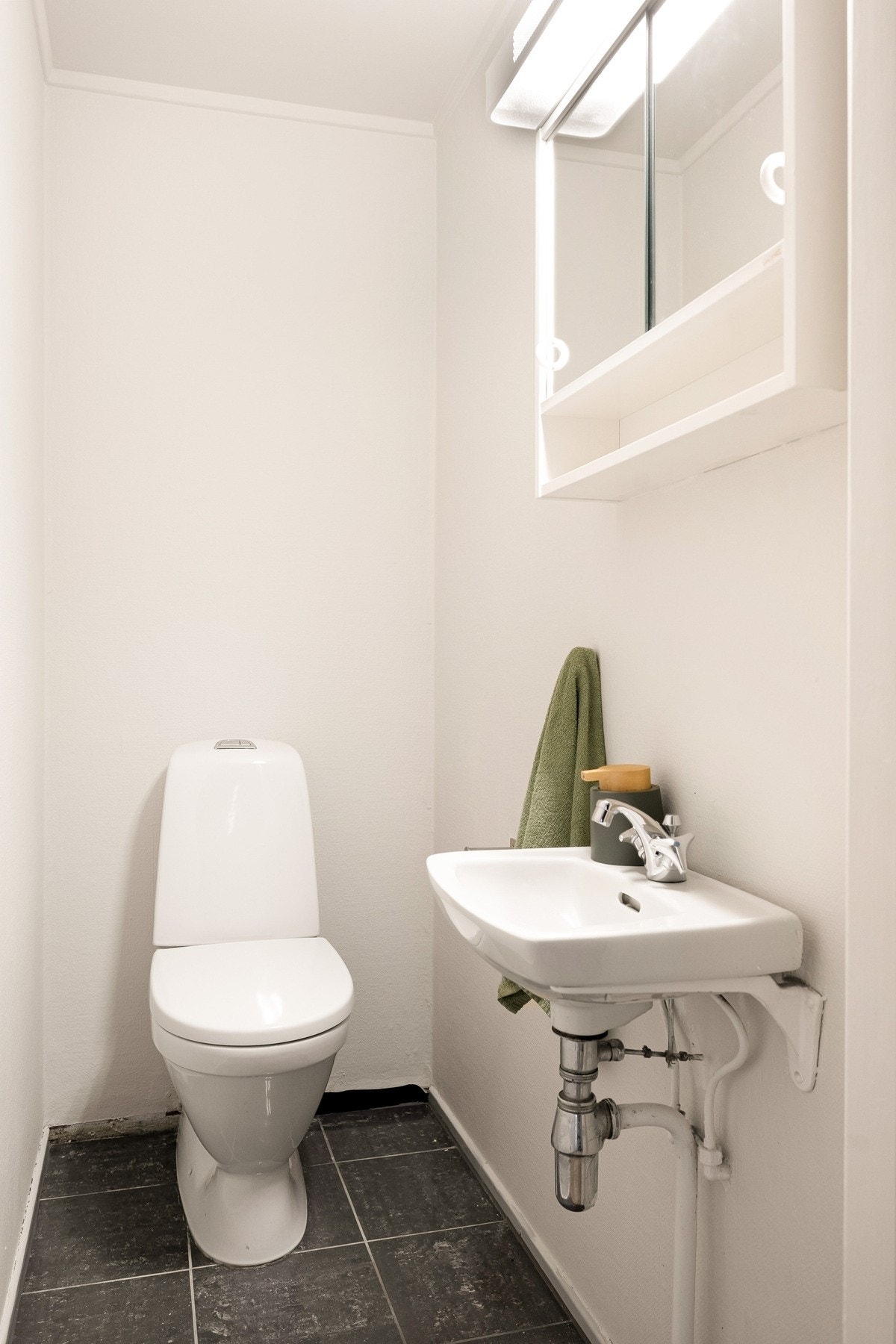 Vegg i vegg med badet finner du et toalettrom med flislagt gulv og malte vegger. Galleribilde