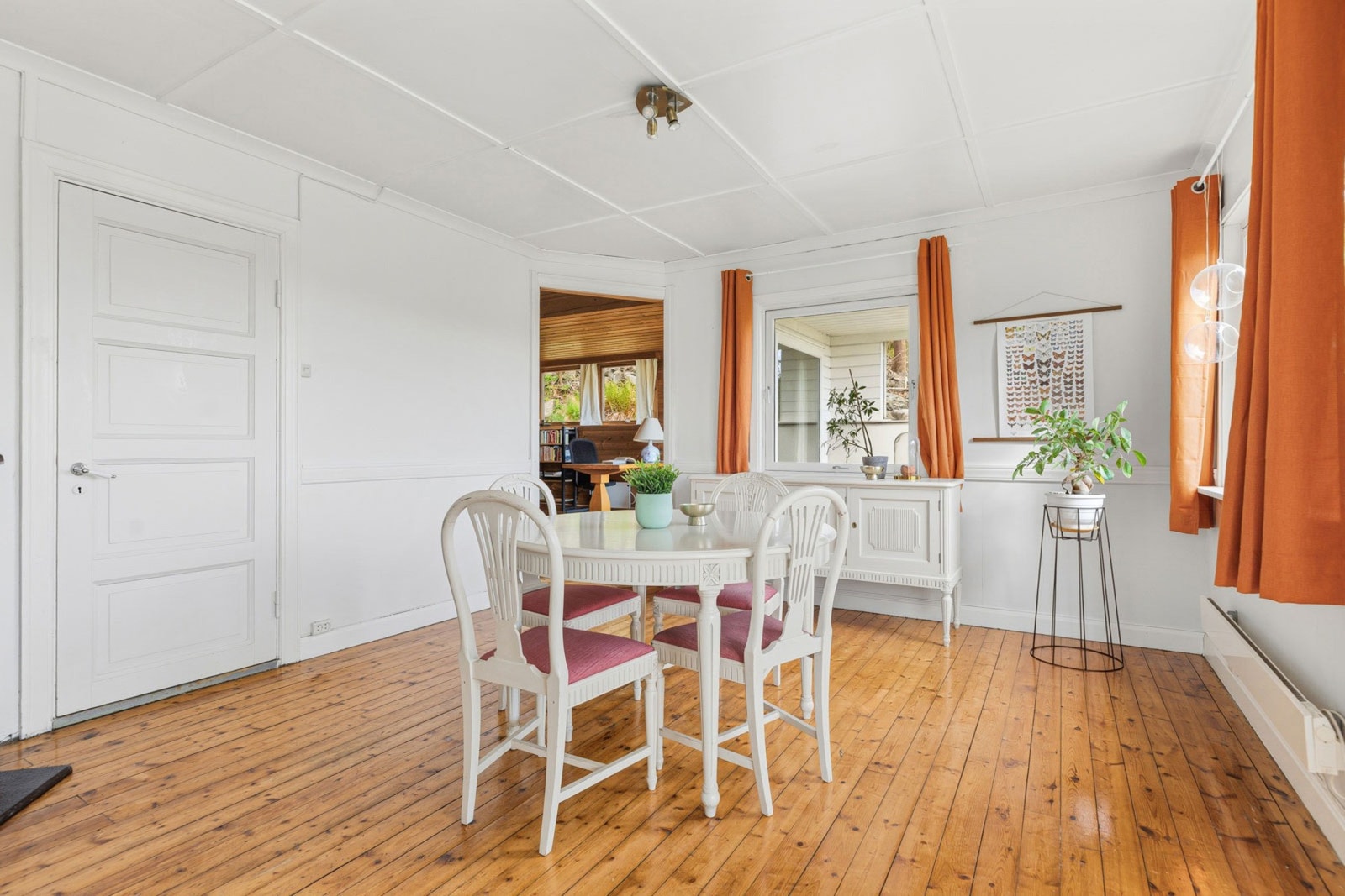 Romslig og lyst rom med hvite vegger, tregulv og store vinduer. Galleribilde