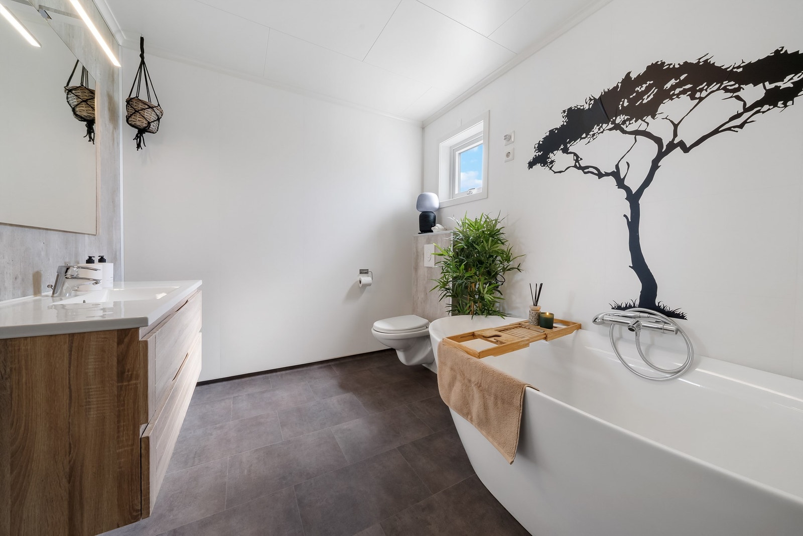 Badet er utstyrt med baderomsinnredning, vegghengt toalett og badekar Galleribilde