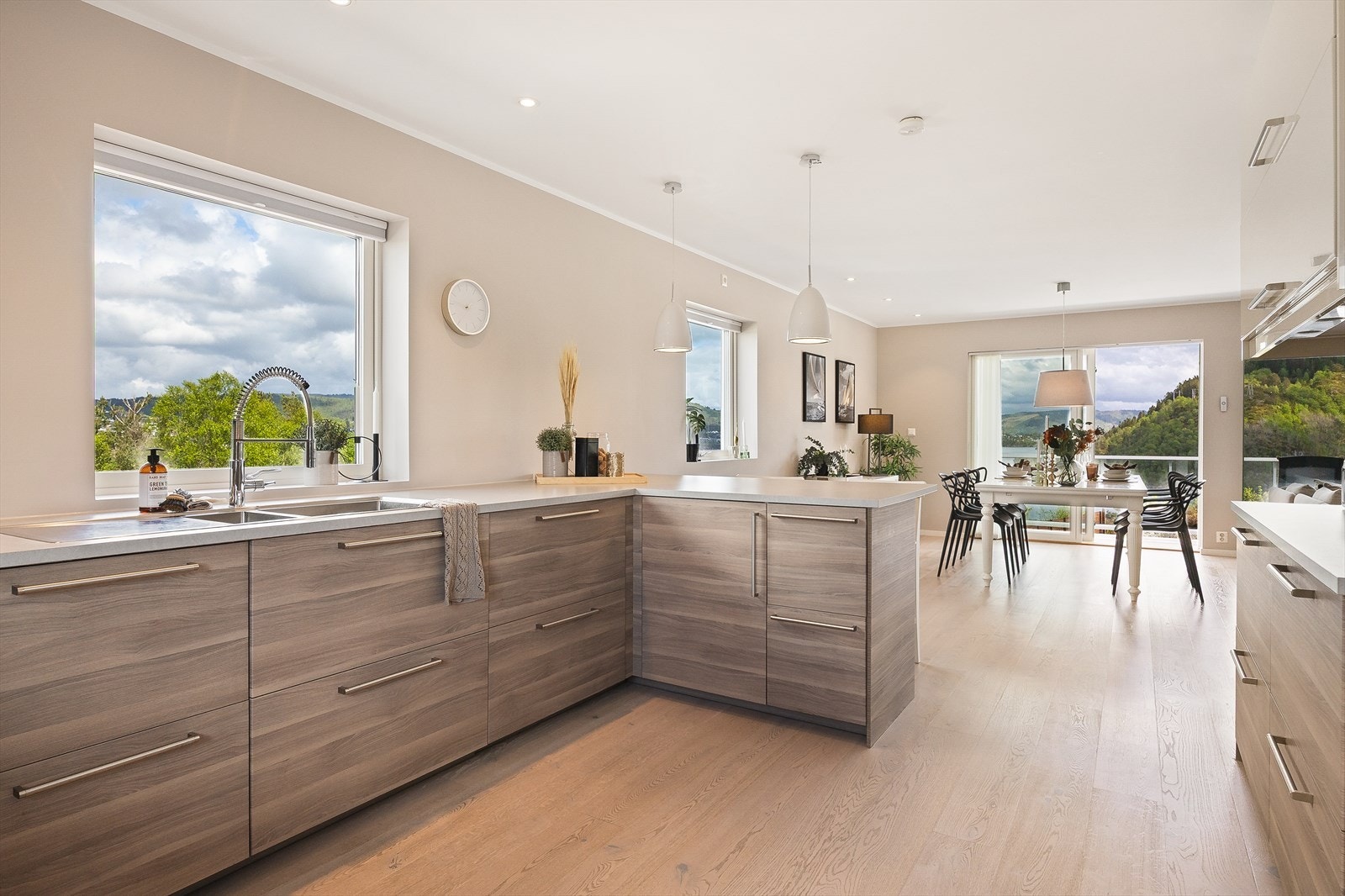 Den åpne løsningen mellom kjøkken og stue skaper et sosialt og luftig allrom med gjennomgående enstavs parkett. Galleribilde