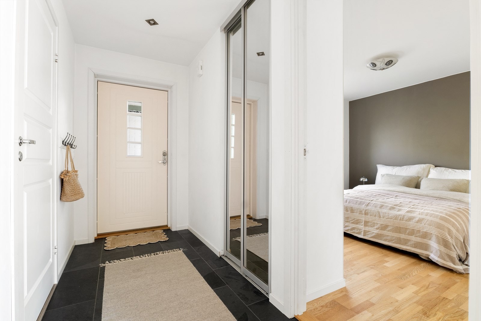 Entréen er lys og innbydende, og er innredet med en stor skyvedørsgarderobe med speildører som gir praktisk oppbevaring av yttertøy og sko. Galleribilde