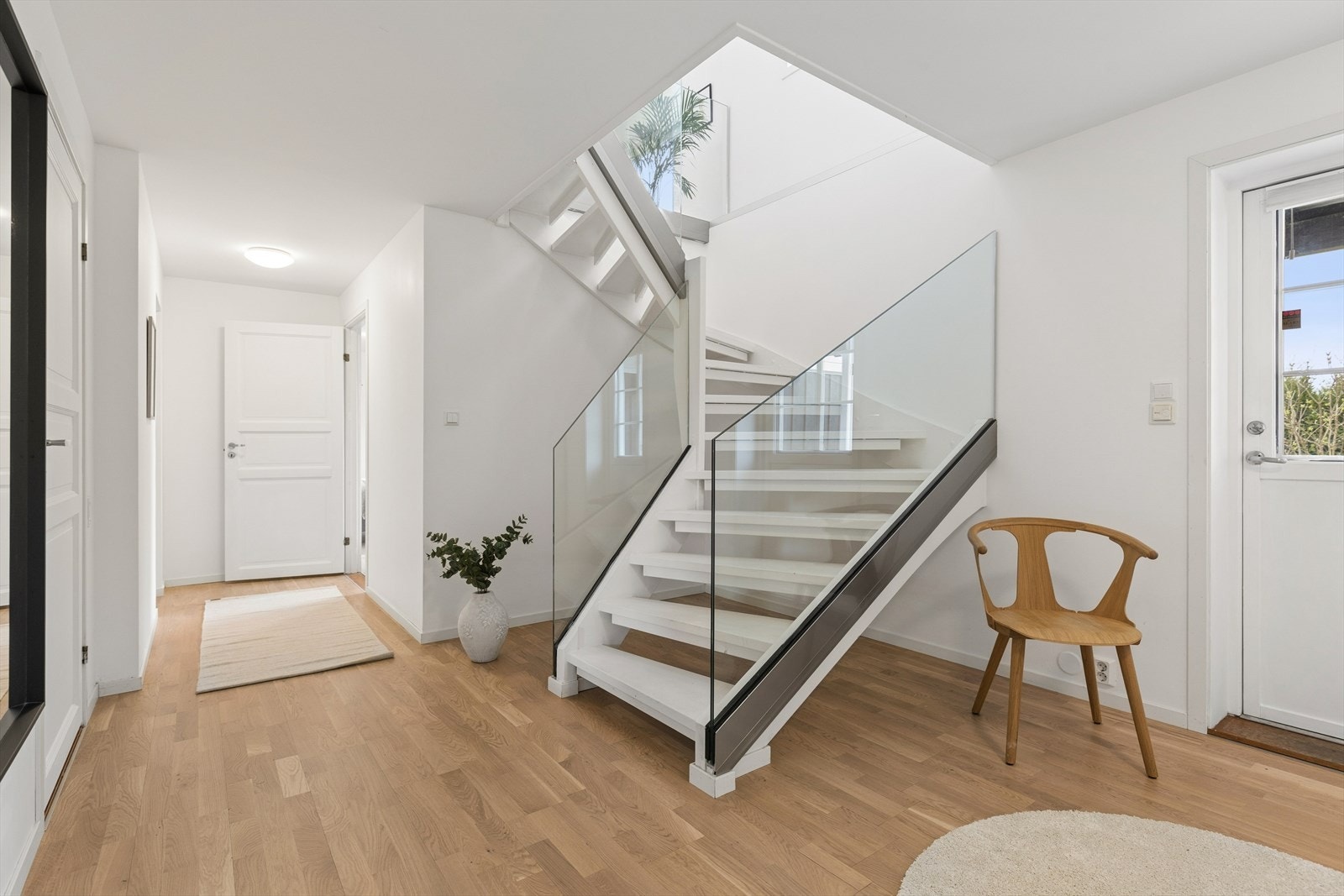 Fra gangen i 1. etasje leder trappen med glassrekkverk ned til boligens underetasjen. Etasjen ligger delvis under terreng. Galleribilde