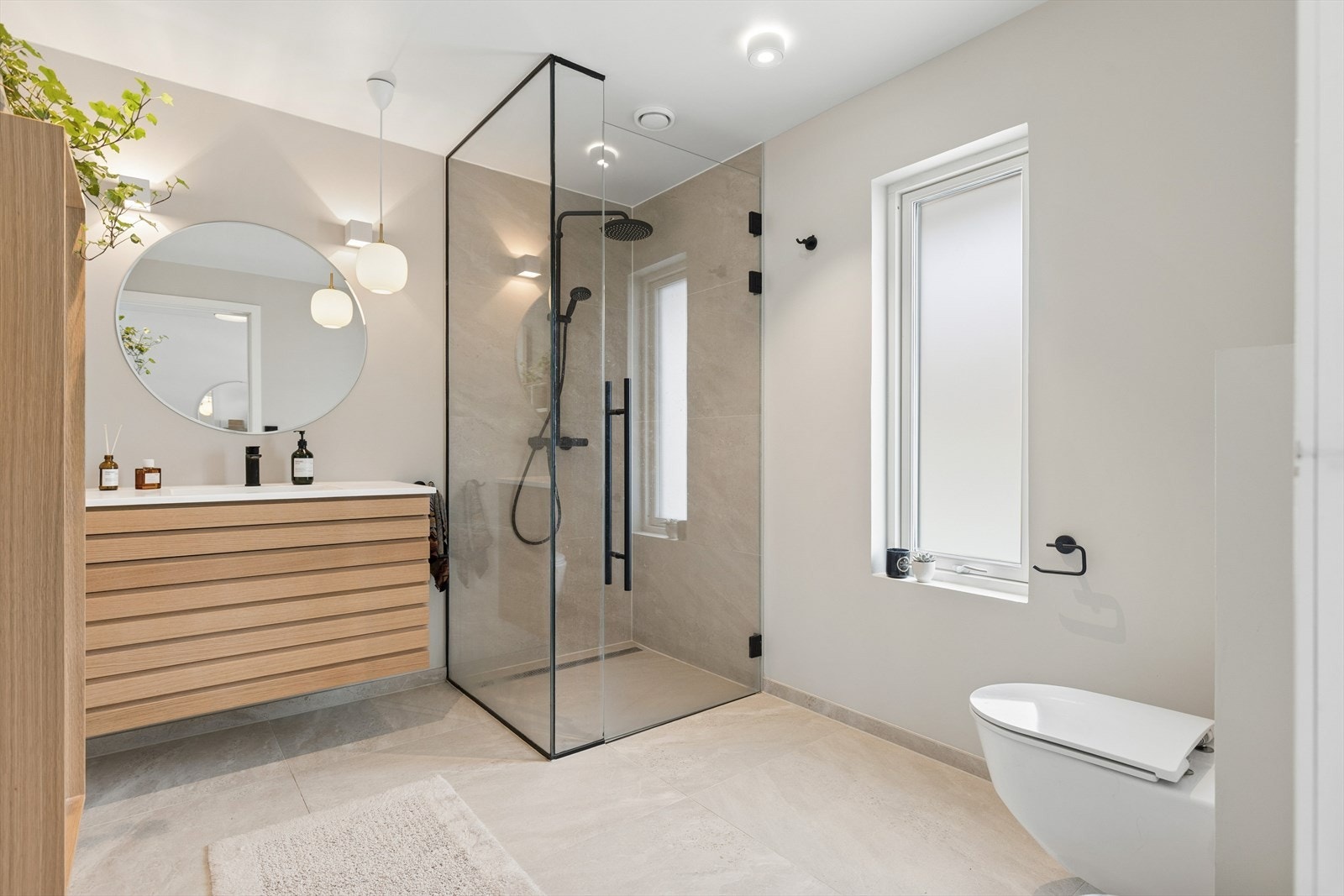 Badet i 1. etasje ble pusset opp i 2023. Rommet har store fliser på gulvet og på vegg i dusjnisje. Galleribilde