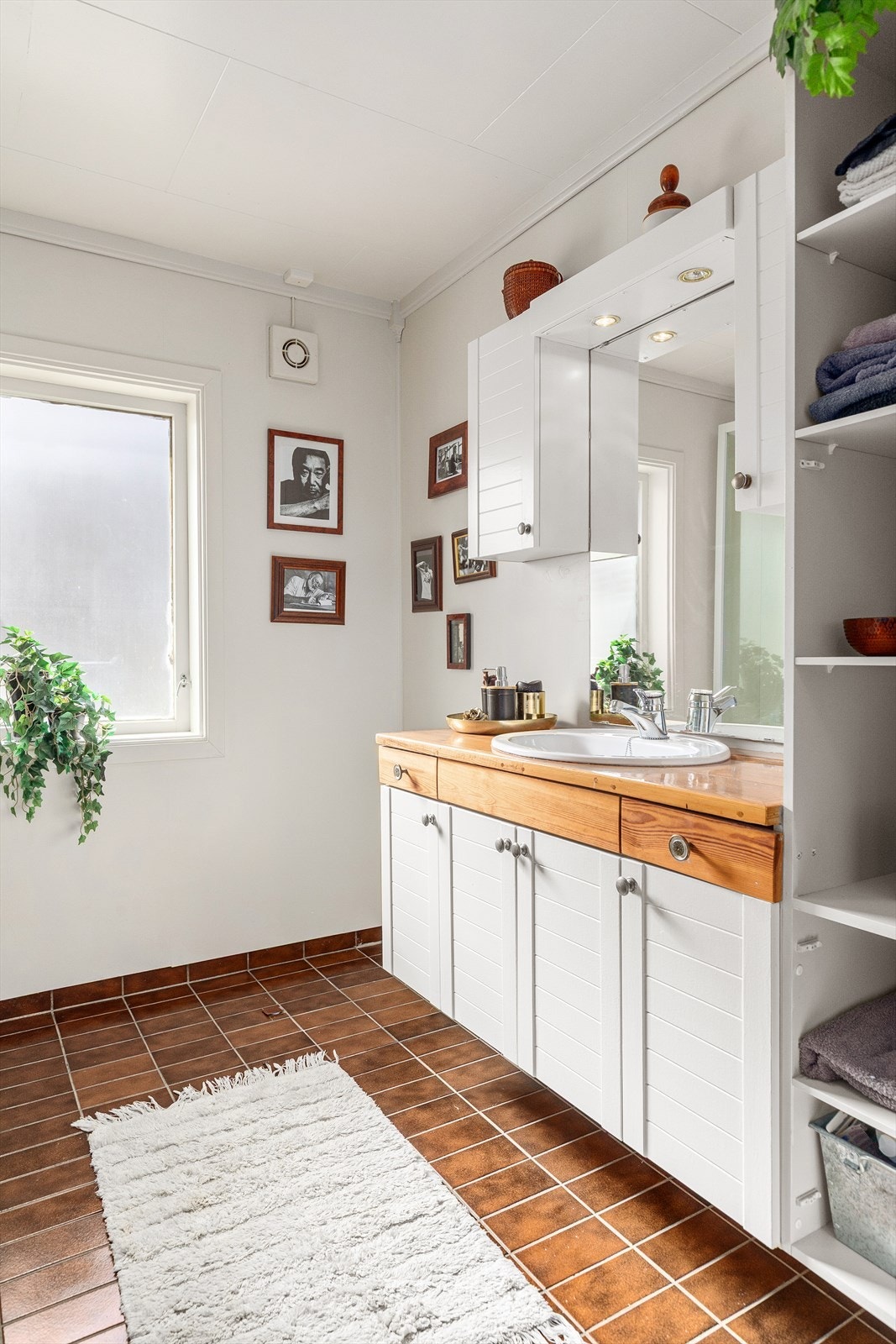Servantskapet har profilerte lyse fronter med en benkeplate i heltre og en nedfelt keramisk servant, samt ettgreps blandebatteri i rustfritt stål. Over servanten er det et overskap med speil. Galleribilde