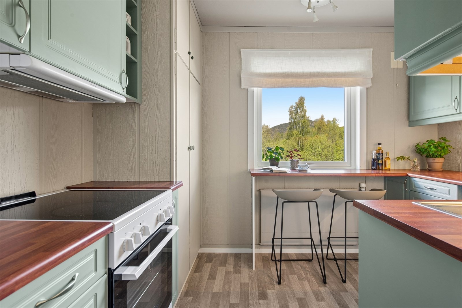 Kjøkkeninnredning fra Sigdal med profilerte fronter og benkeplate i laminat. Galleribilde
