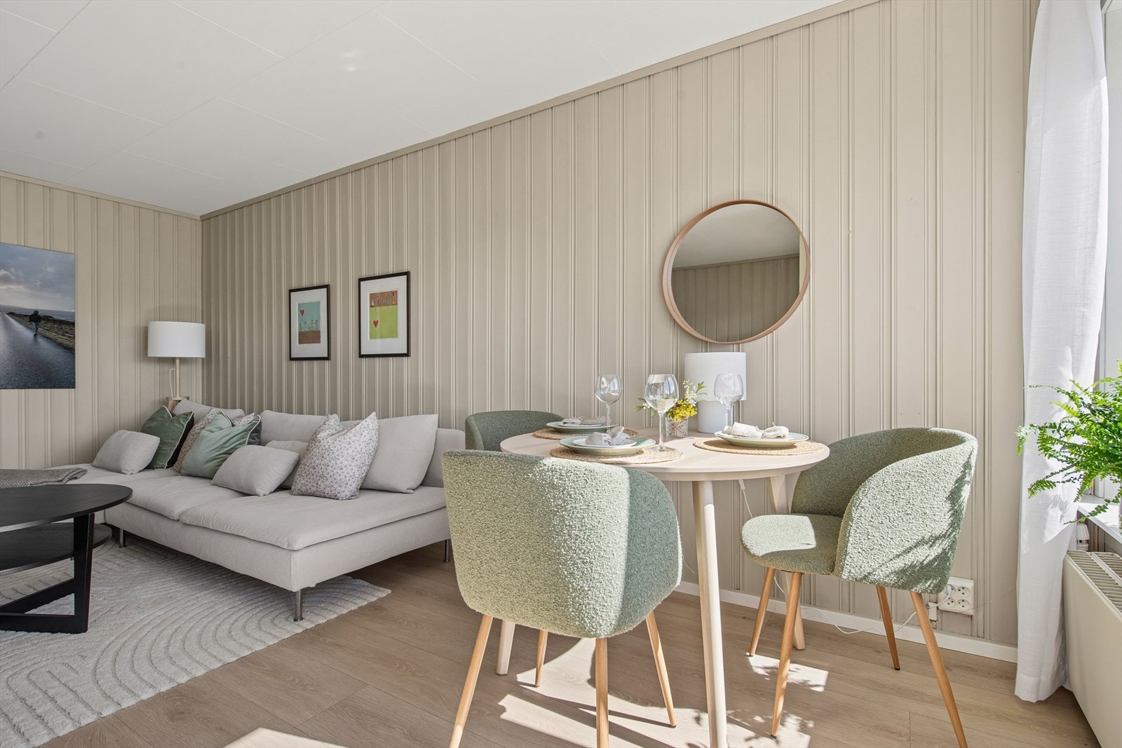 Stuen har god plass til både sofagruppe og spisebord. Rommet varmes opp av en radiator tilknyttet borettslagets vannbårne system. Galleribilde