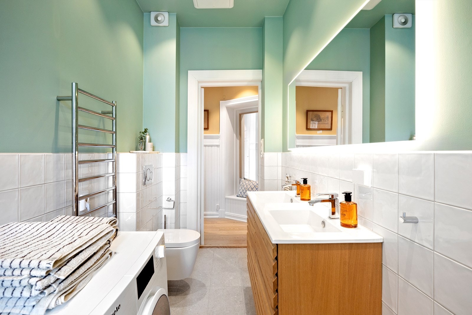 Badet er utstyrt med to servanter, dusj i badekar, vegghengt klosett og opplegg for vaskemaskin. Galleribilde
