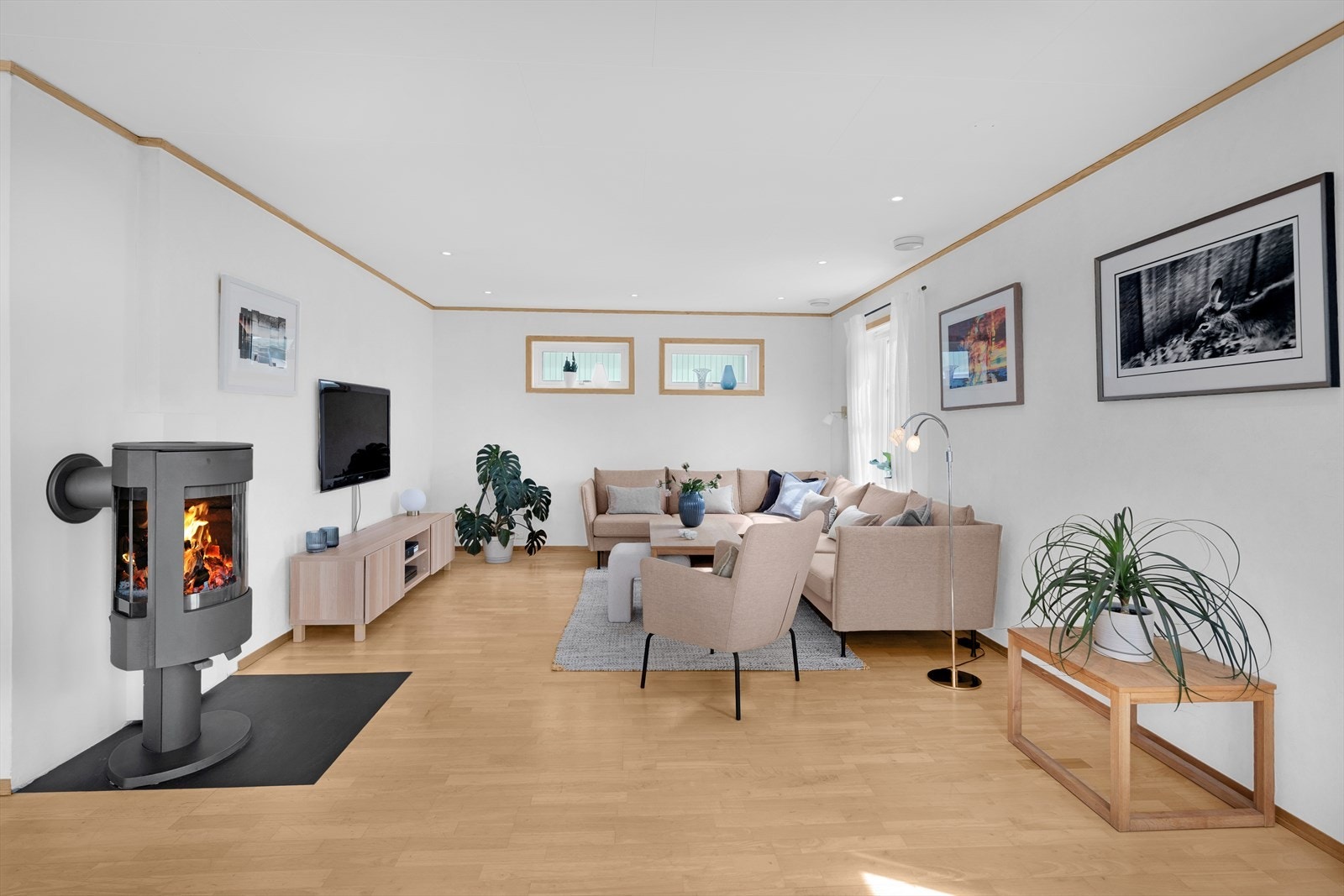 1. etg: Lys og fin stue med parkett på gulv, lysmalte veggoverflater og downlights i taket Galleribilde