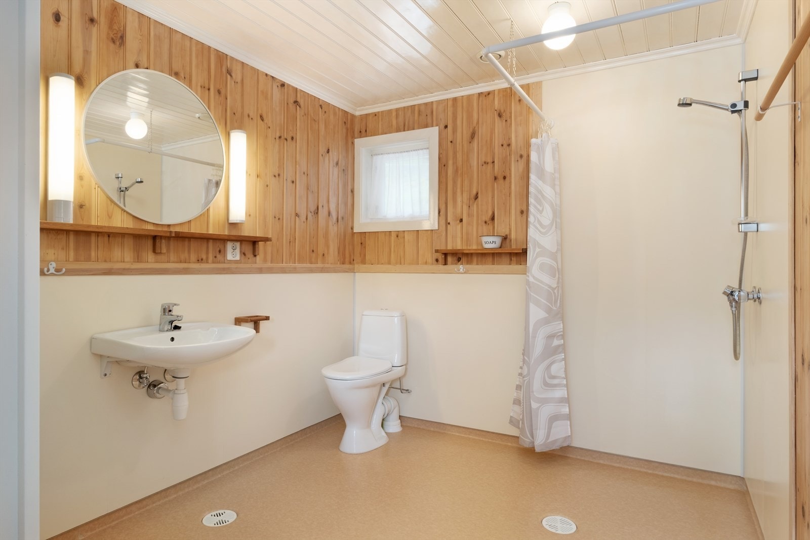 Badet i hovudetasjen har vinylbelegg på golv og elektriske varmekablar i golv.
Innreiia med dusj, servant og wc. Galleribilde