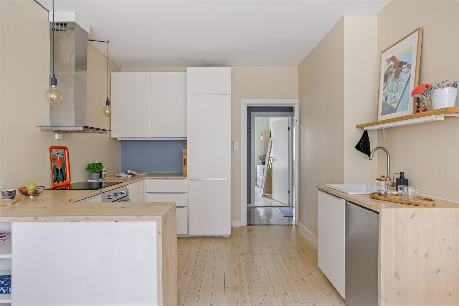 Innredning med glatte, folierte fronter. Benkeplate i treverk med nedfelt kum i keramikk. Galleribilde