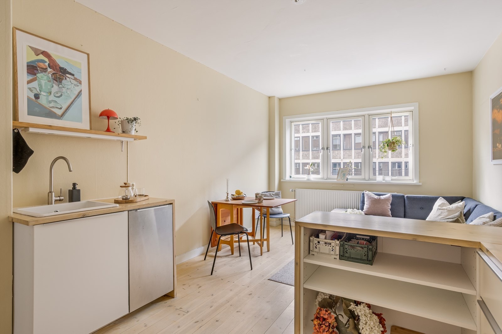 Åpen kjøkkenløsning som holder en normal standard. Innredning med glatte, folierte fronter. Benkeplate i treverk med nedfelt kum i keramikk. Galleribilde