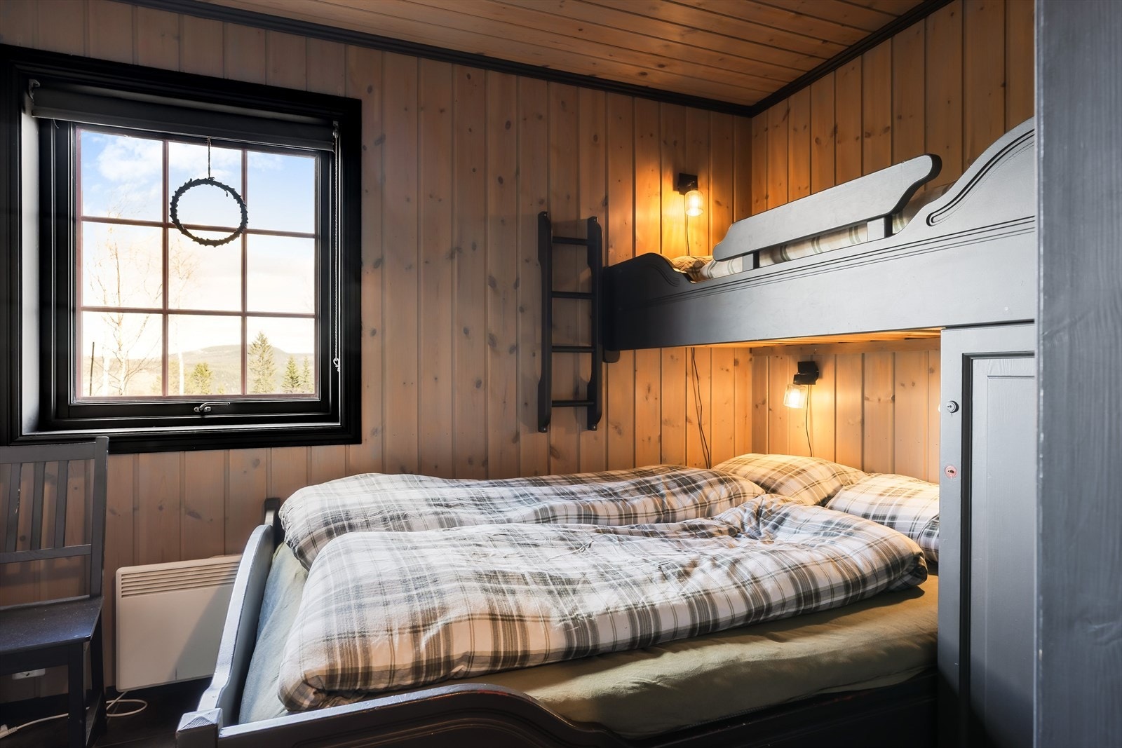 Et av soverommene, med flislagt gulv og panelovn for oppvarming. Galleribilde