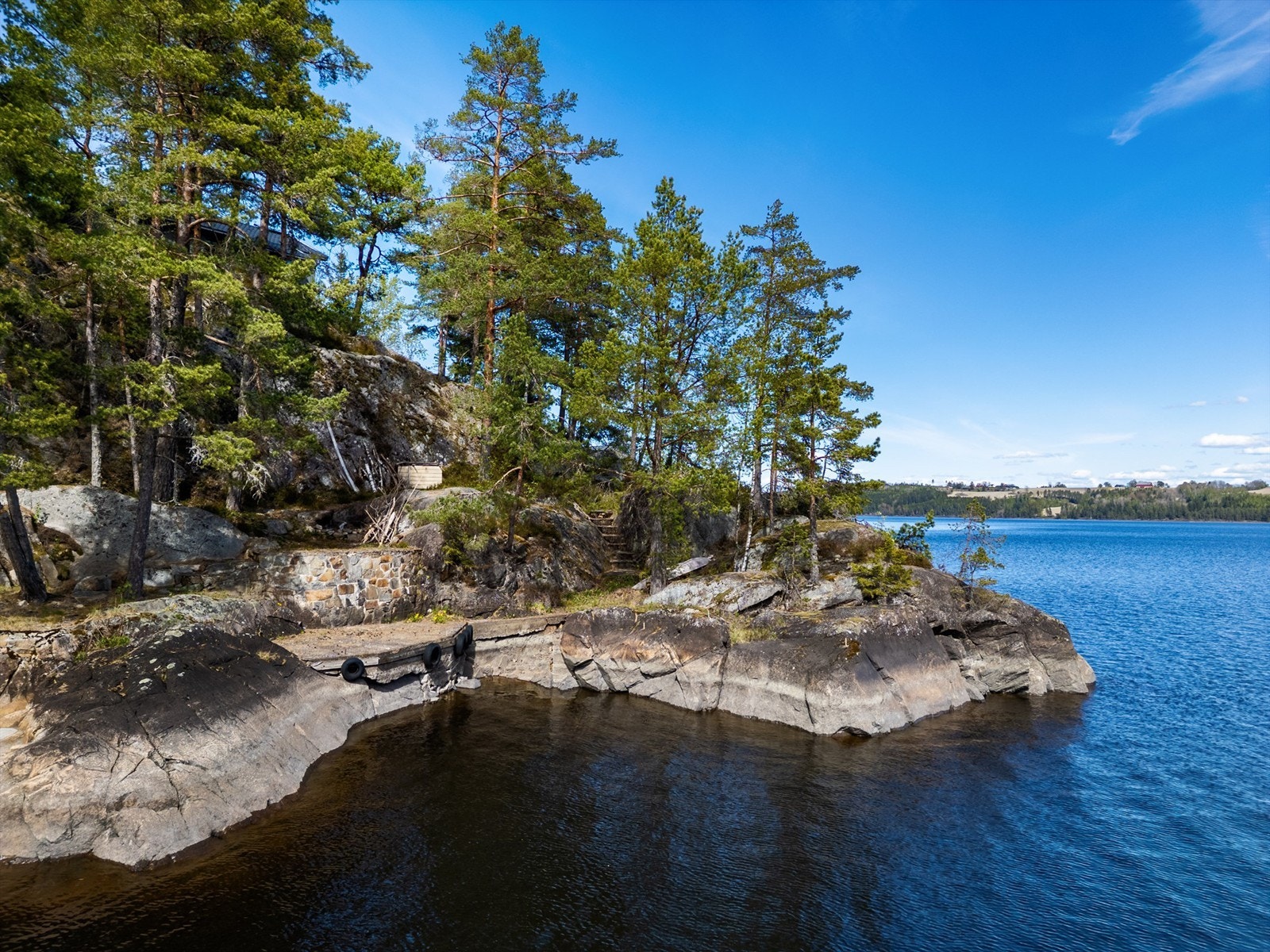 Det er støpt opp egen brygg på nede ved vannet samt fine svaberg som frister ved varme sommerdager Galleribilde