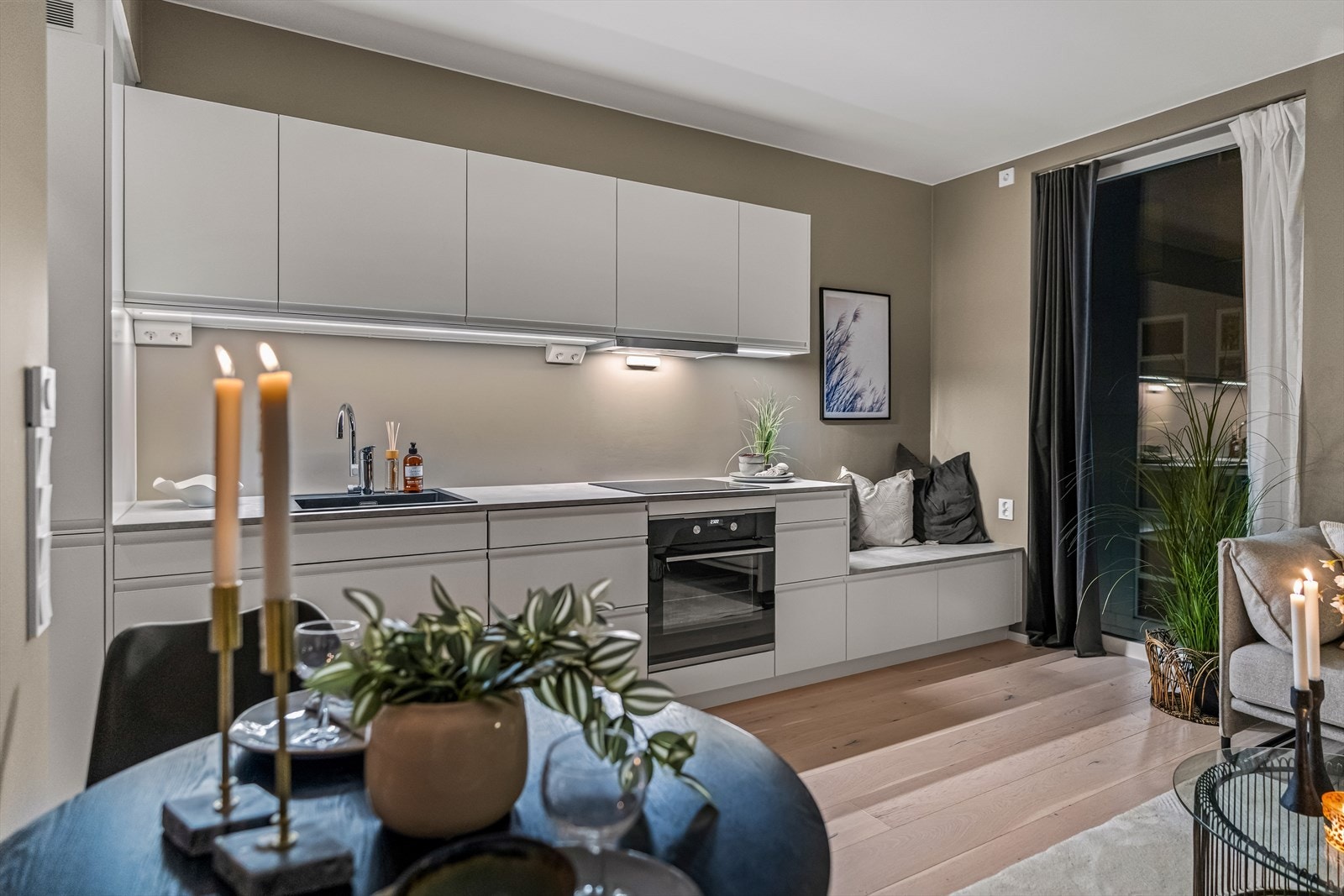 Innredningen har hvite, glatte fronter med gripekant, kombinert med benkeplate i grå laminat. Galleribilde