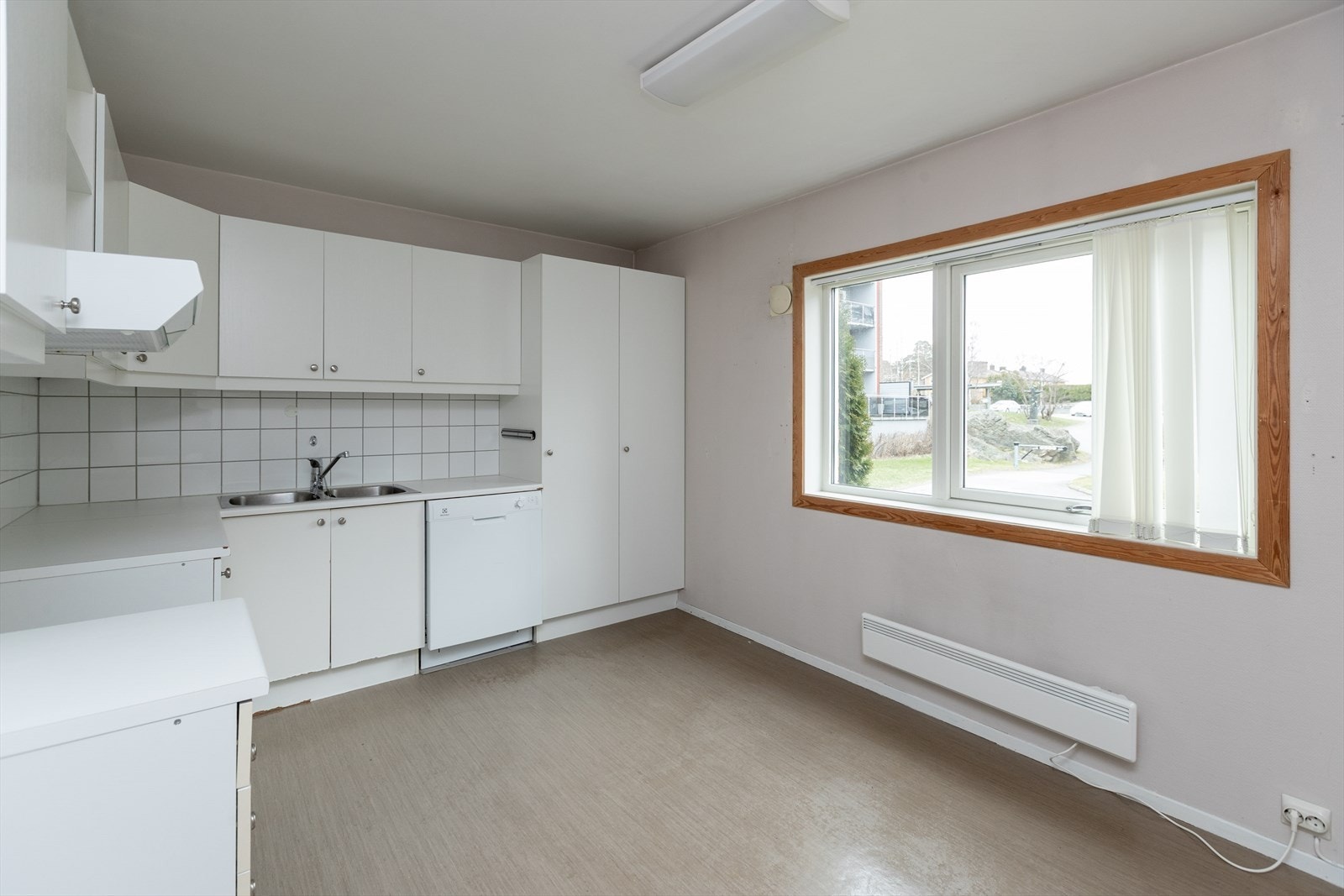Kjøkkenet har glatte fronter og benkeplate av laminat, samt underbygget oppvaskmaskin. Galleribilde