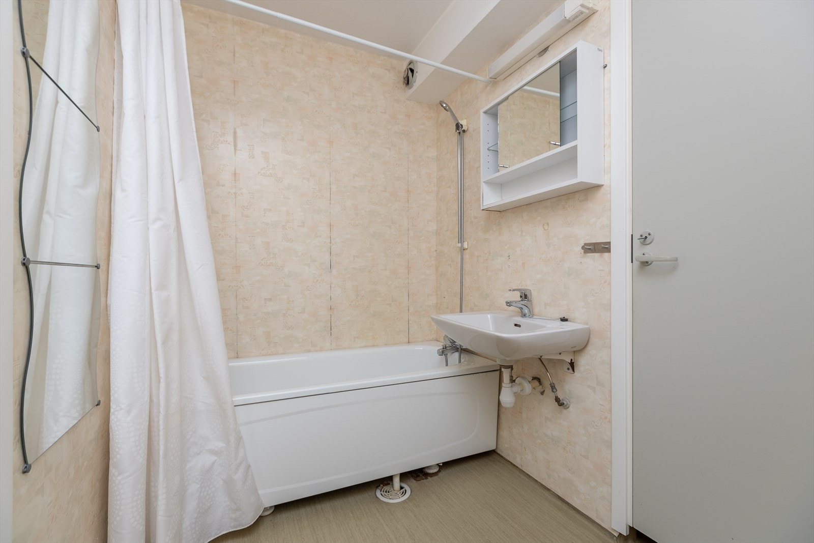 Badet har veggoverflater av våtromstapet og praktisk oppbevaringsskap over servanten. Galleribilde