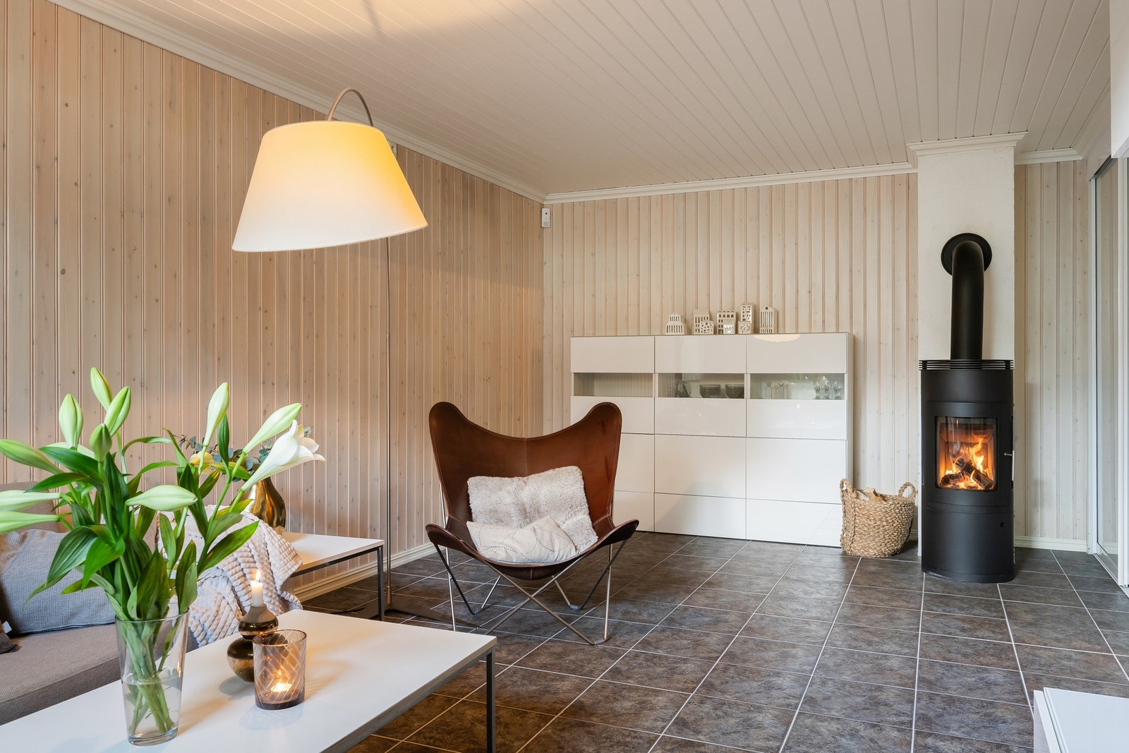 Romslig kjellerstue på 23m² med peis og doble dører ut mot hall. Galleribilde