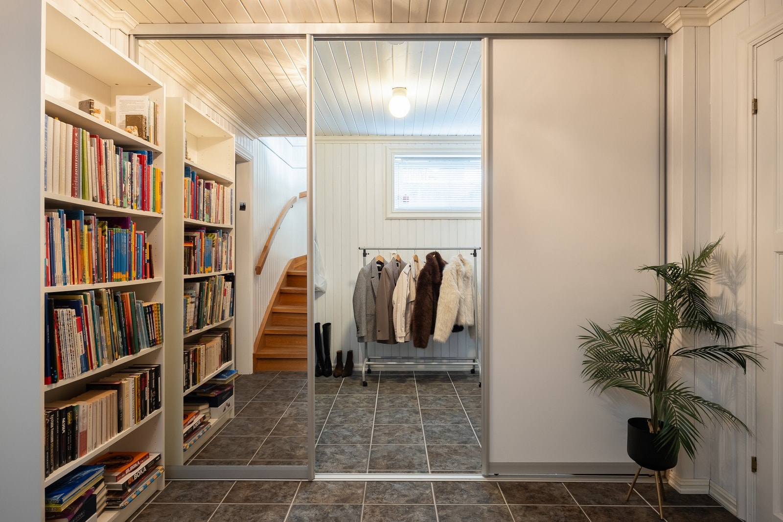 Hallen er delt med skyvedører til garderoberom. Rommet har fliser på gulv og varmekabler. Galleribilde