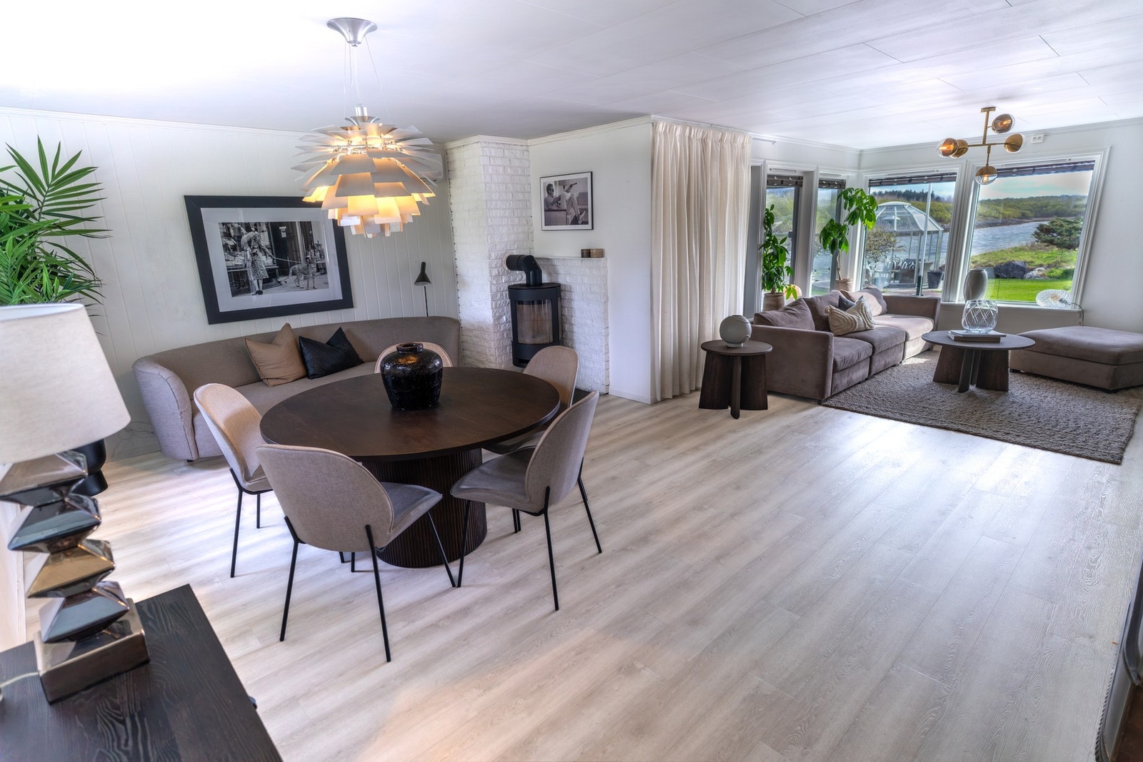 Stuen har god plass til både sofagruppe og spisebord. En ny vedovn ble installert i 2022. Galleribilde