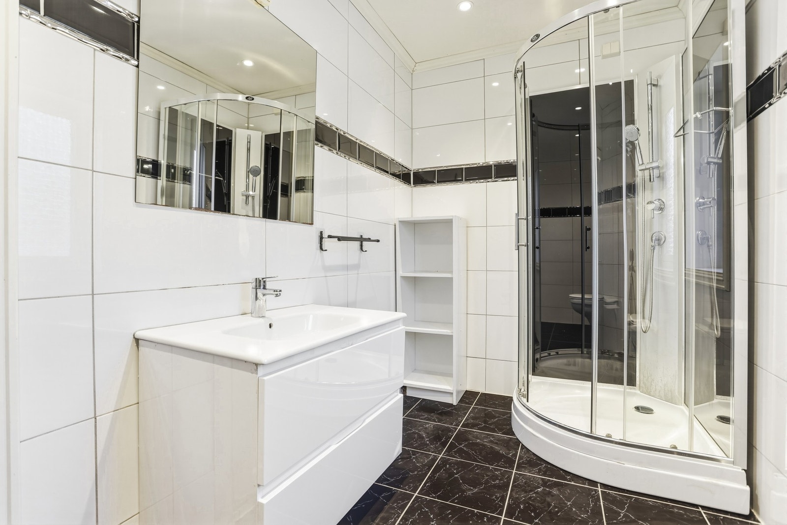 Badet i 1.etg ble oppgradert i 2013 og inneholder dusjkabinett, veggmontert toalett og innredning med skuffer og heldekkende servant. Galleribilde