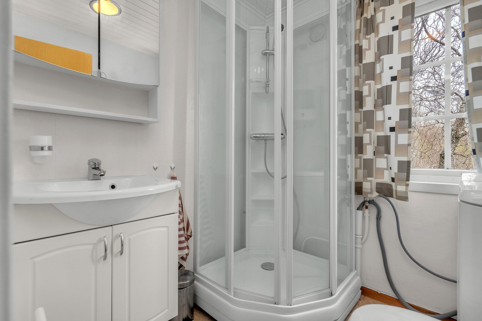 Badet har baderomsinnredning med servant, dusjkabinett, toalett
og opplegg for vaskemaskin Galleribilde
