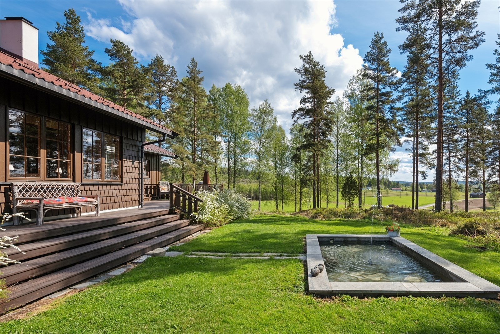 Tomten ligger høyt i terrenget med flott utsikt utover åpne landbruksareal og skogkledde åser. Galleribilde