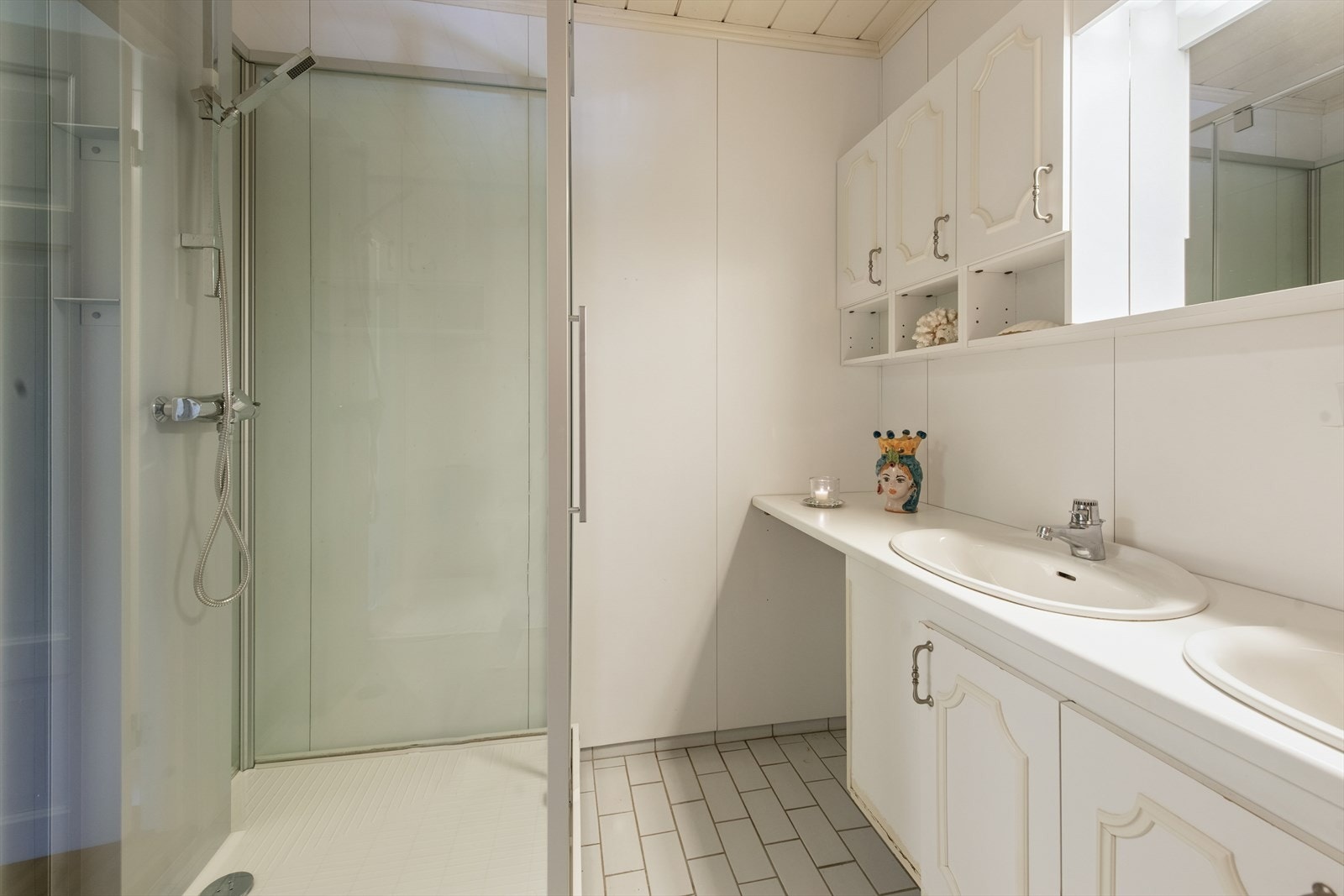Badet til hovedsoverommet har fliser på gulv og baderomsplater på veggene. Galleribilde