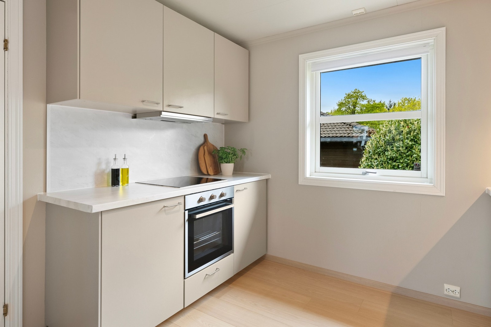 Innredningen har slette/profilerte fronter, pen benkeplate, integrerte hvitevarer som kjøle-/fryseskap, stekeovn, platetopp og oppvaskmaskin. Galleribilde
