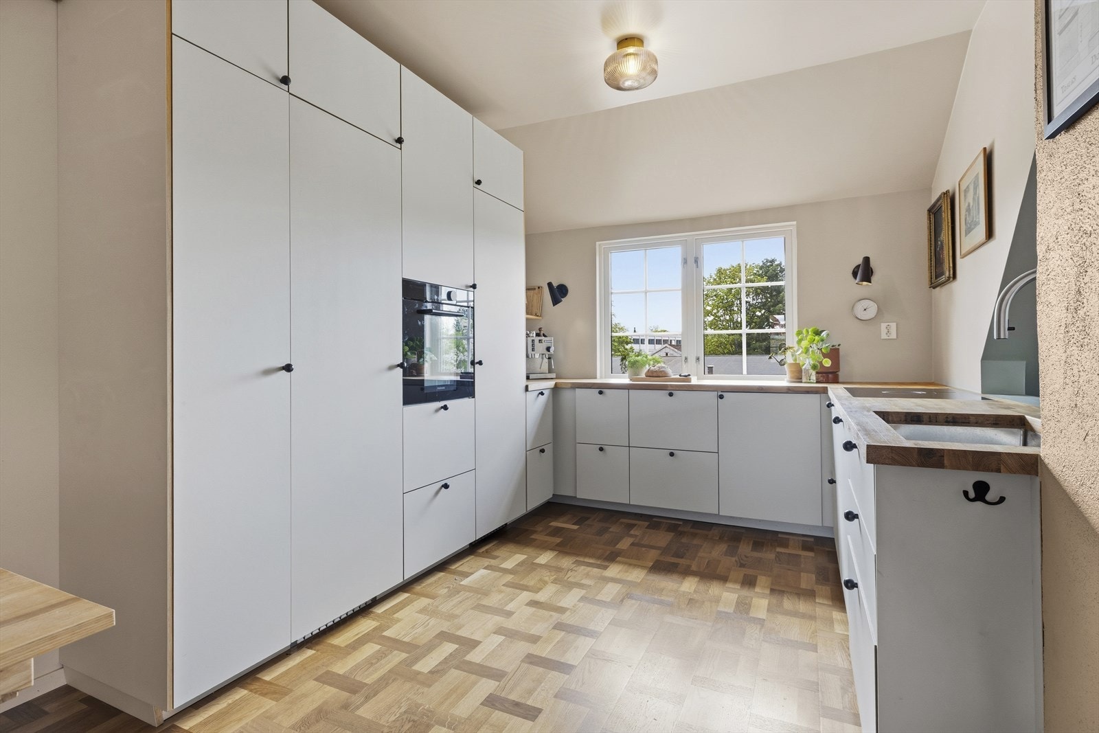 Hvitevarer bestående av induksjon koketopp, stekeovn, kjøleskap, fryser og oppvaskmaskin. Ventilator integrert i kokesone. Galleribilde