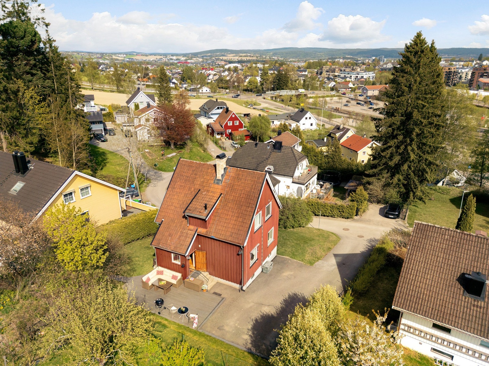 Den asfalterte innkjørselen gir praktisk adkomst og gode parkeringsmuligheter på egen tomt, samtidig som eiendommen oppleves skjermet og hjemmekoselig. Galleribilde
