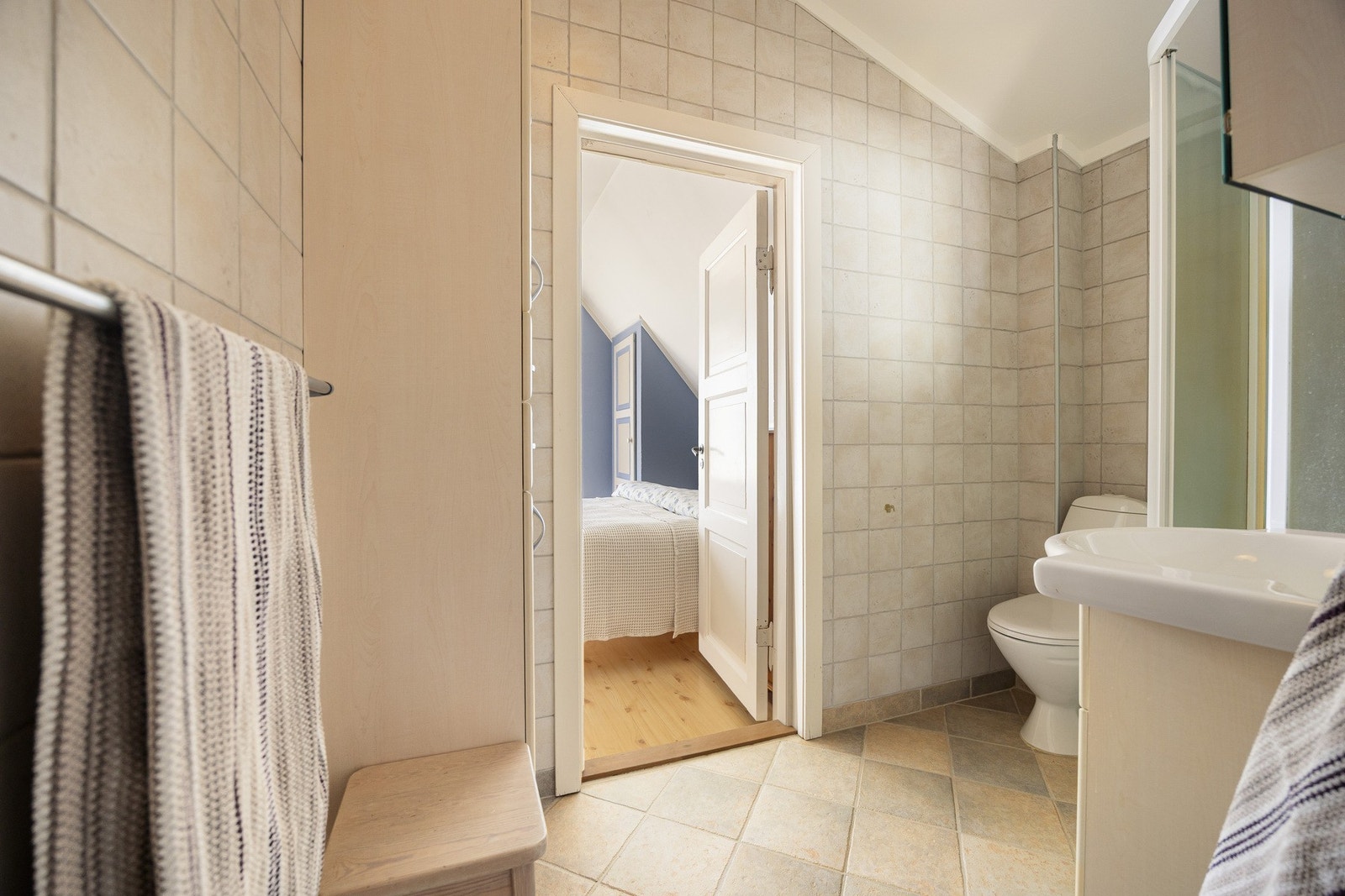 Badet har en praktisk utforming med flislagte overflater og gulvvarme som gir komfort i hverdagen. Rommet fungerer fint slik det står i dag, samtidig som det gir mulighet for fremtidig modernisering tilpasset egne ønsker og behov. Galleribilde
