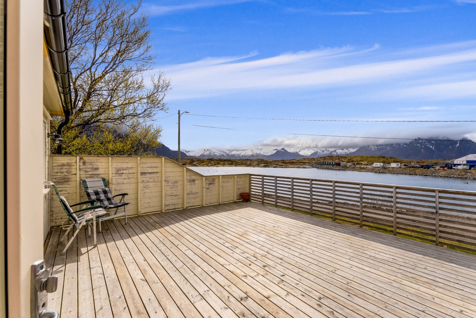 Romslig terrasse med flott utsikt mot sjø og fjell. Galleribilde