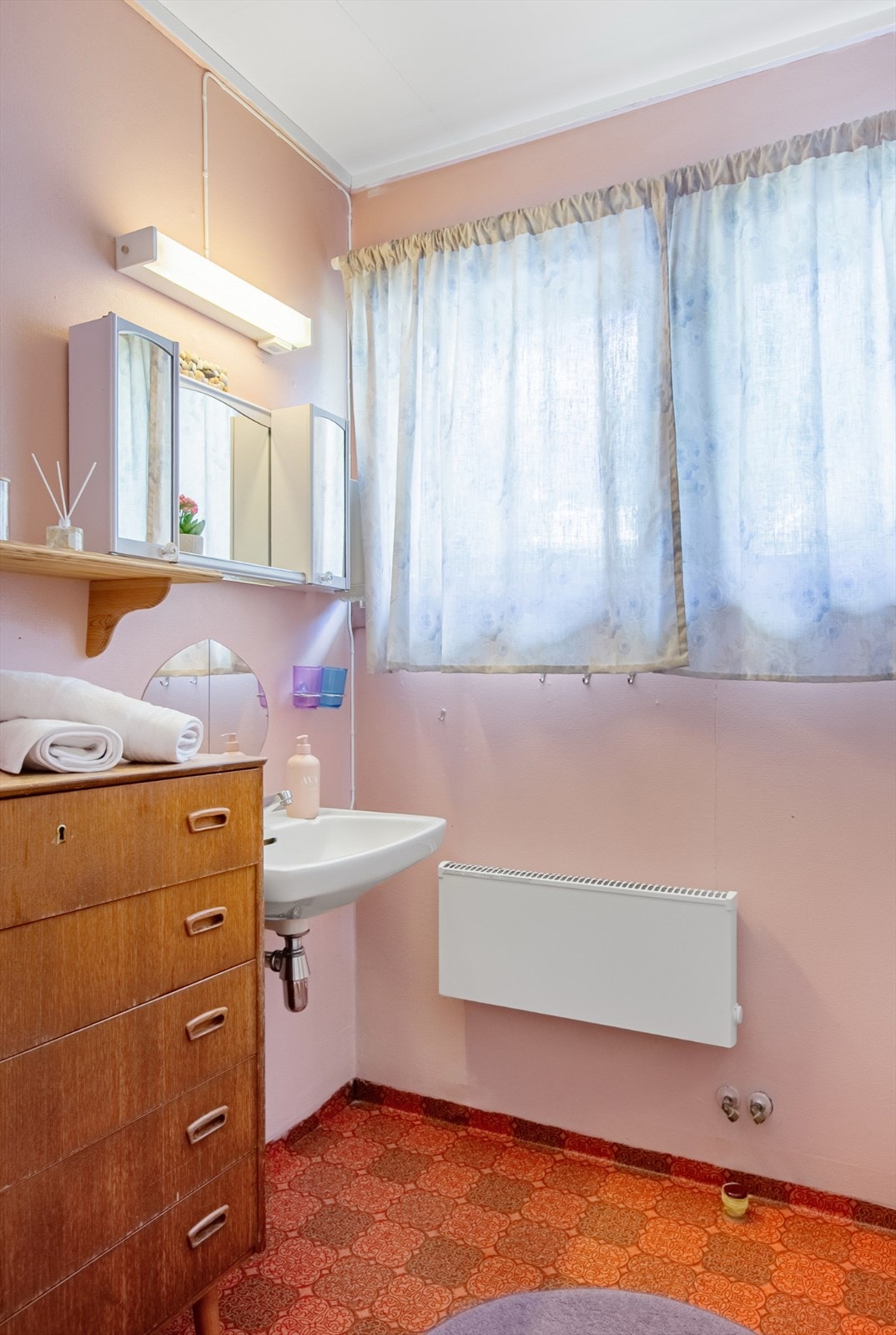 I hovedetasjen er det et eldre bad med belegg på gulv og malte plater på vegger. Her er det vegghengt servant, frittstående dusjkabinett og varmtvannsbereder på ca. 200 l. Badet varmes opp av panelovn og har avtrekksvifte i himling. Galleribilde