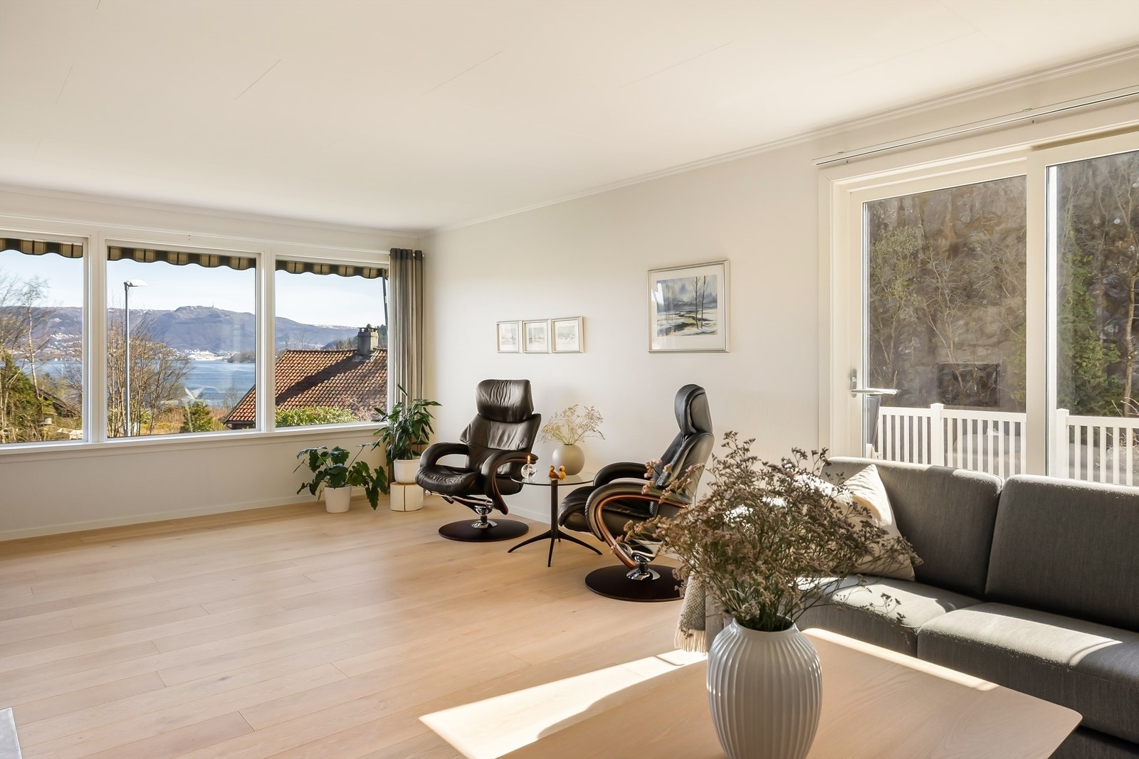 De brede vinduene i stuen fungerer som levende malerier, med en stadig skiftende utsikt mot innseilingen til Bergen. Galleribilde