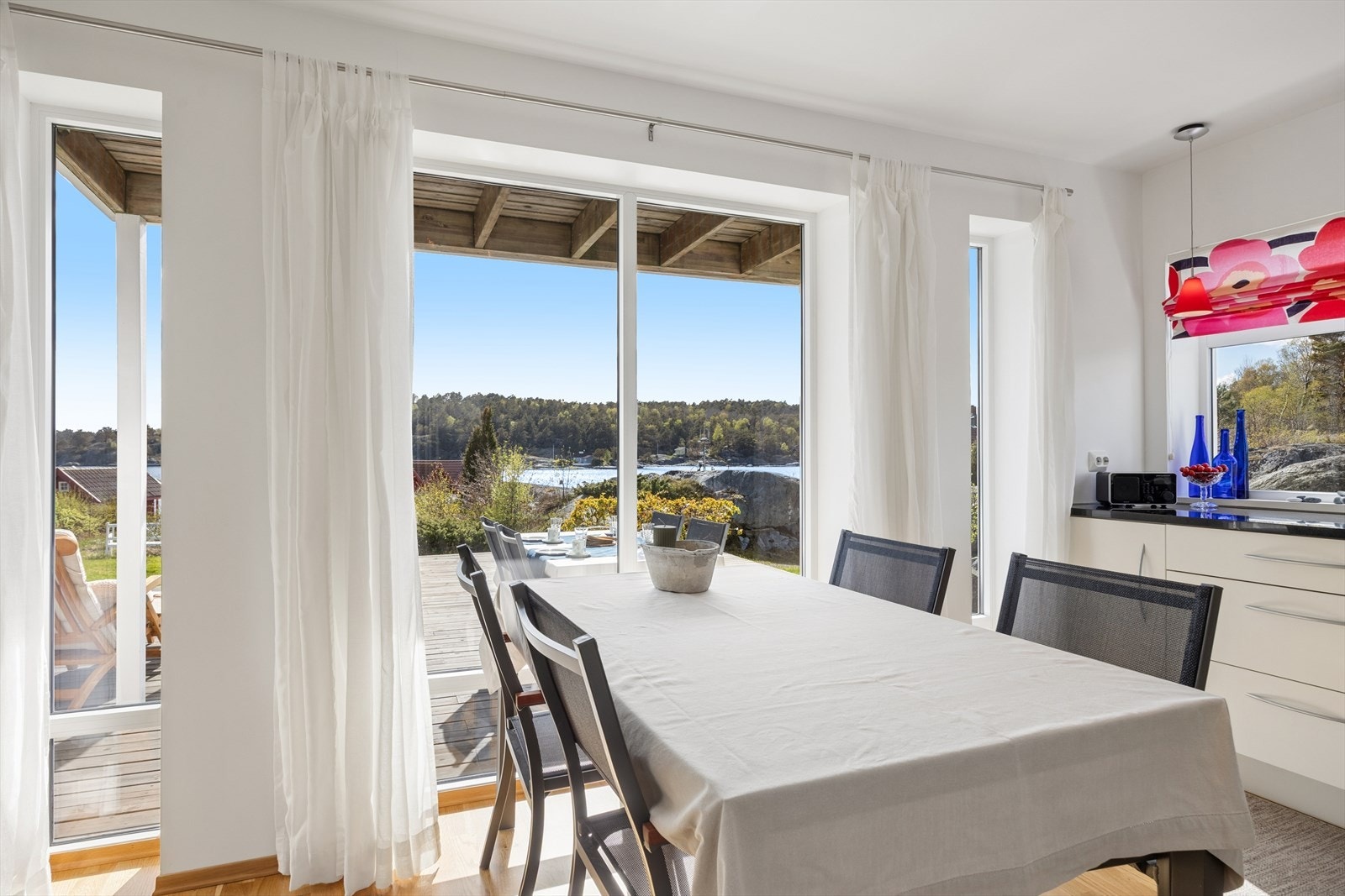 Kjøkken har plass til stort spisebord. Også herfra er det flott utsikt mot Furøysund gjennom de store vinduene. Galleribilde
