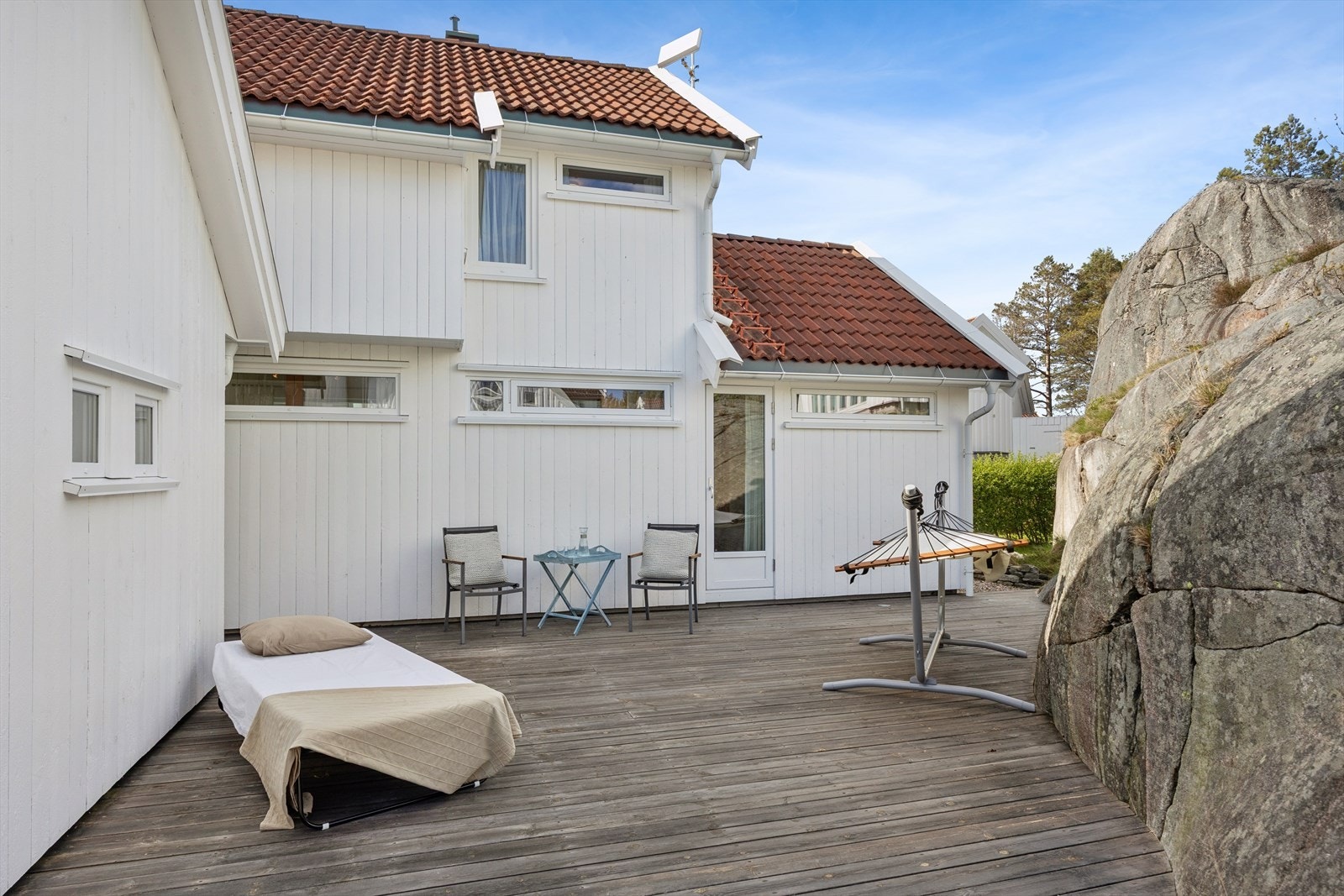 Lun uteplass på baksiden av hytten. I kroken til venstre er det dør inn til stue/kjøkken. Døren rett frem er til hoved soverommet. Terrassene og balkongen er oljet etter at bilde ble tatt. Galleribilde