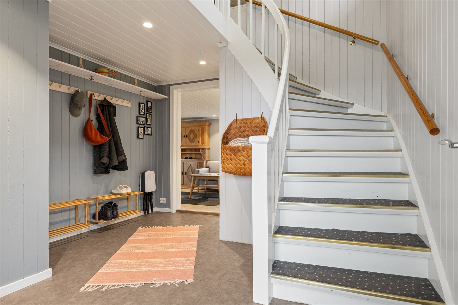 Hallen har plass til yttertøy og sko, og en malt tretrapp binder etasjene sammen. Galleribilde