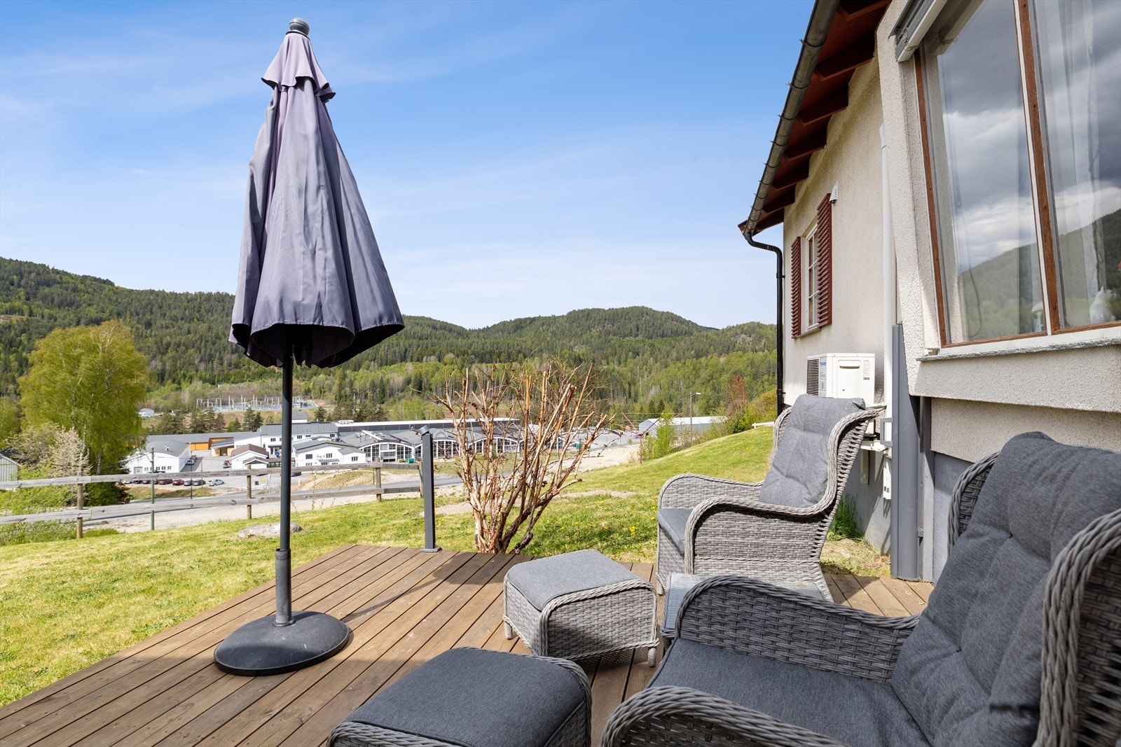 Romslig terrasse med god plass til utemøbler, perfekt for både avslapning og sosiale sammenkomster, og med et hyggelig utsyn over nærområdet. Galleribilde