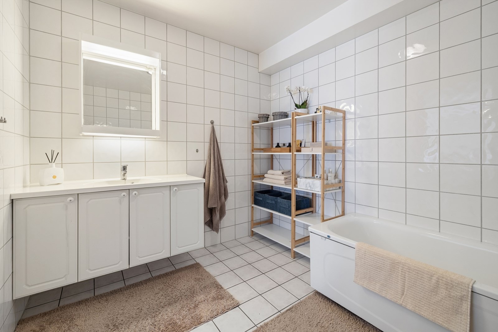 Innredningen består av hel servantplate med servantskap, veggfestet toalett med skjult sisterne og badekar. Galleribilde