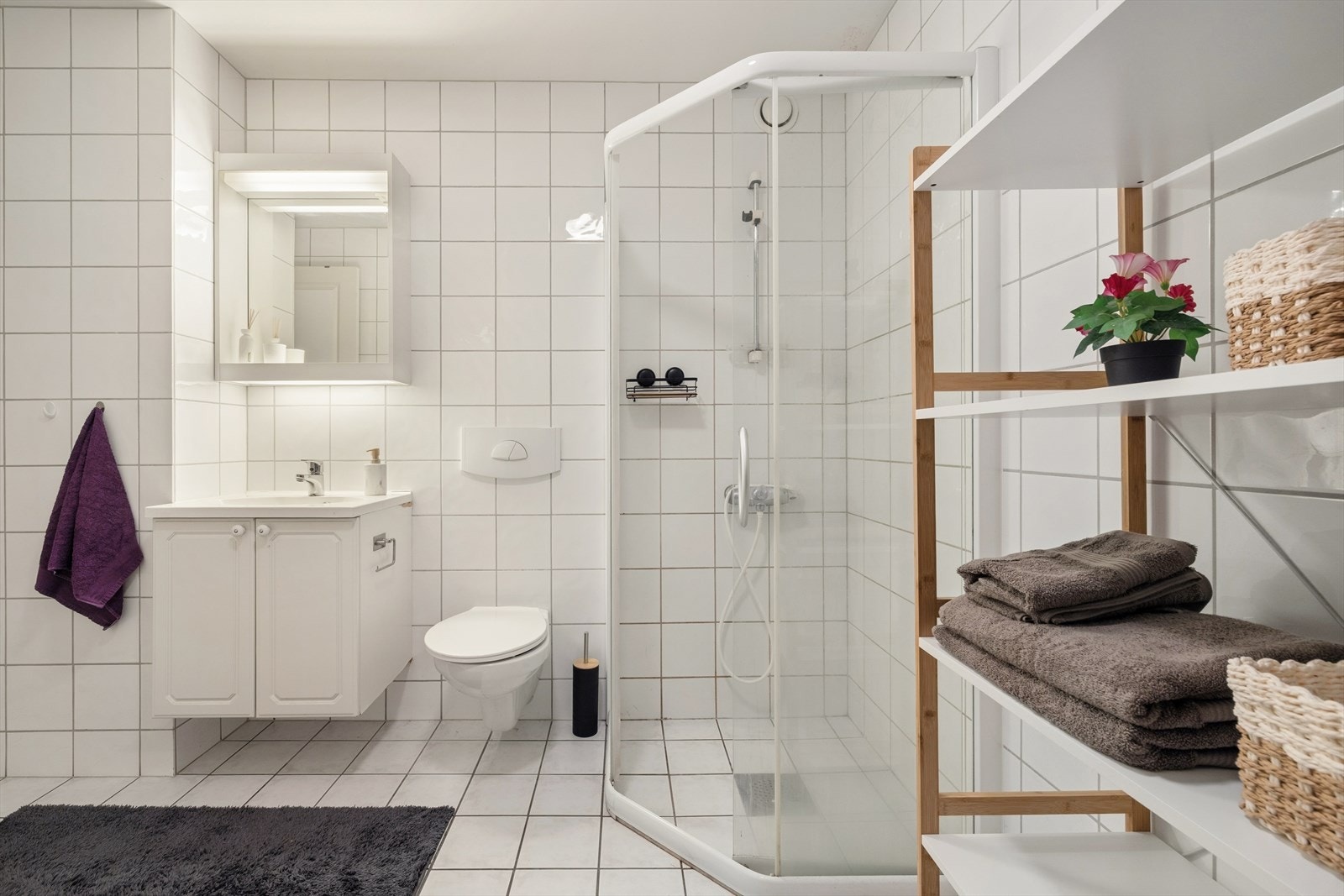 Innredningen består av servant med servantskap, veggfestet toalett med skjult sisterne og hjørnedusj med glassvegger og dører med fast gulvskinne. Galleribilde