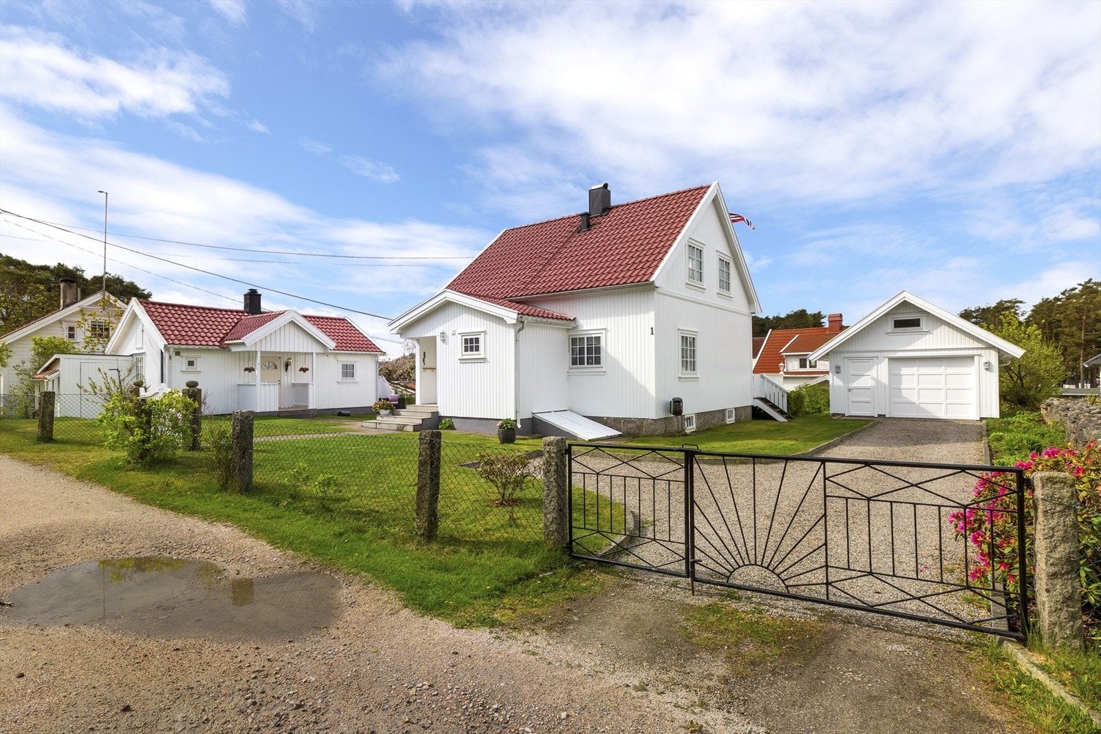 Eiendommen er inngjerdet og har en flott smijernsport ved innkjørselen. Galleribilde