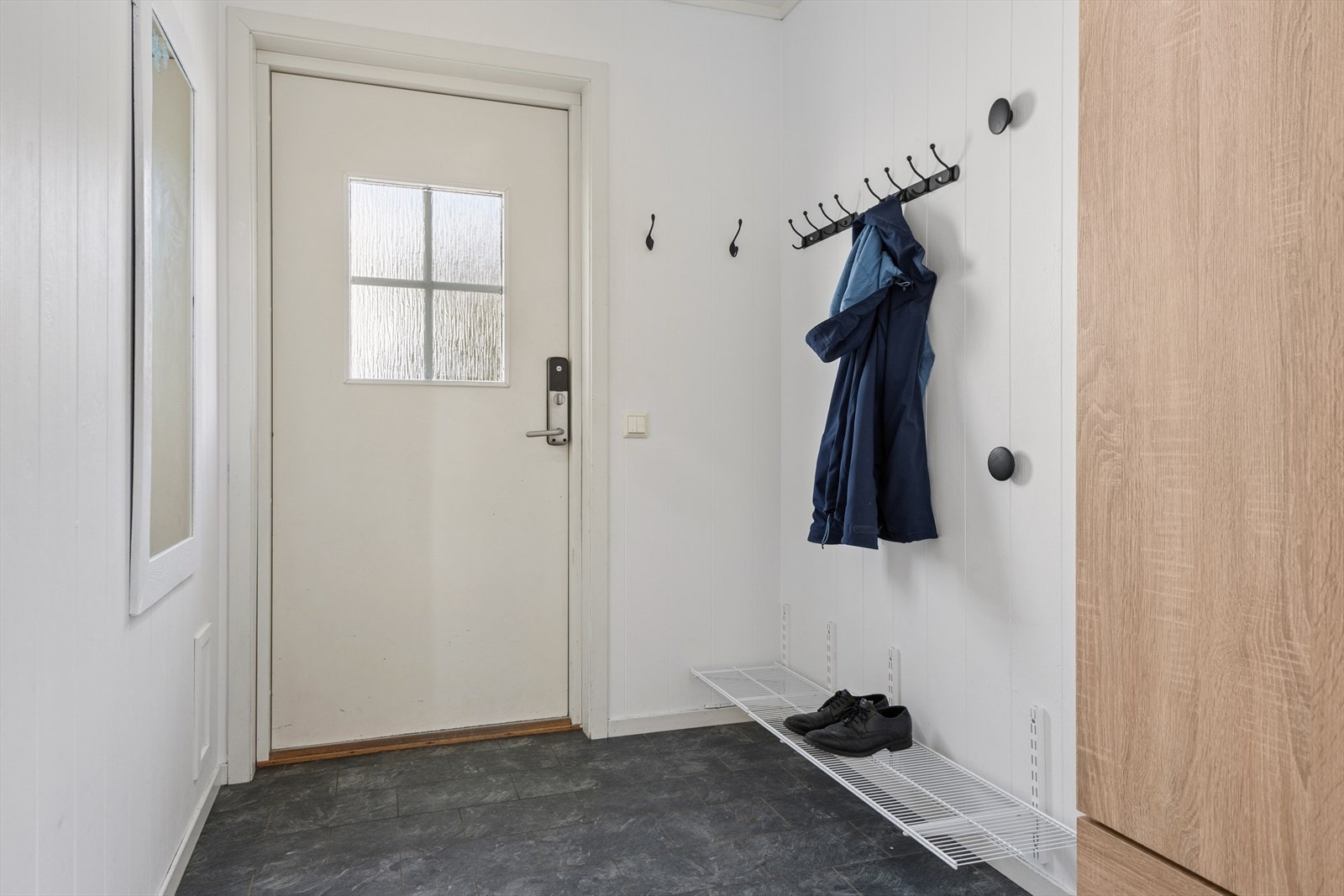 Man ønskes velkommen inn i en romslig entré utstyrt med garderobe som gir god lagringsplass for yttertøy og sko. Galleribilde
